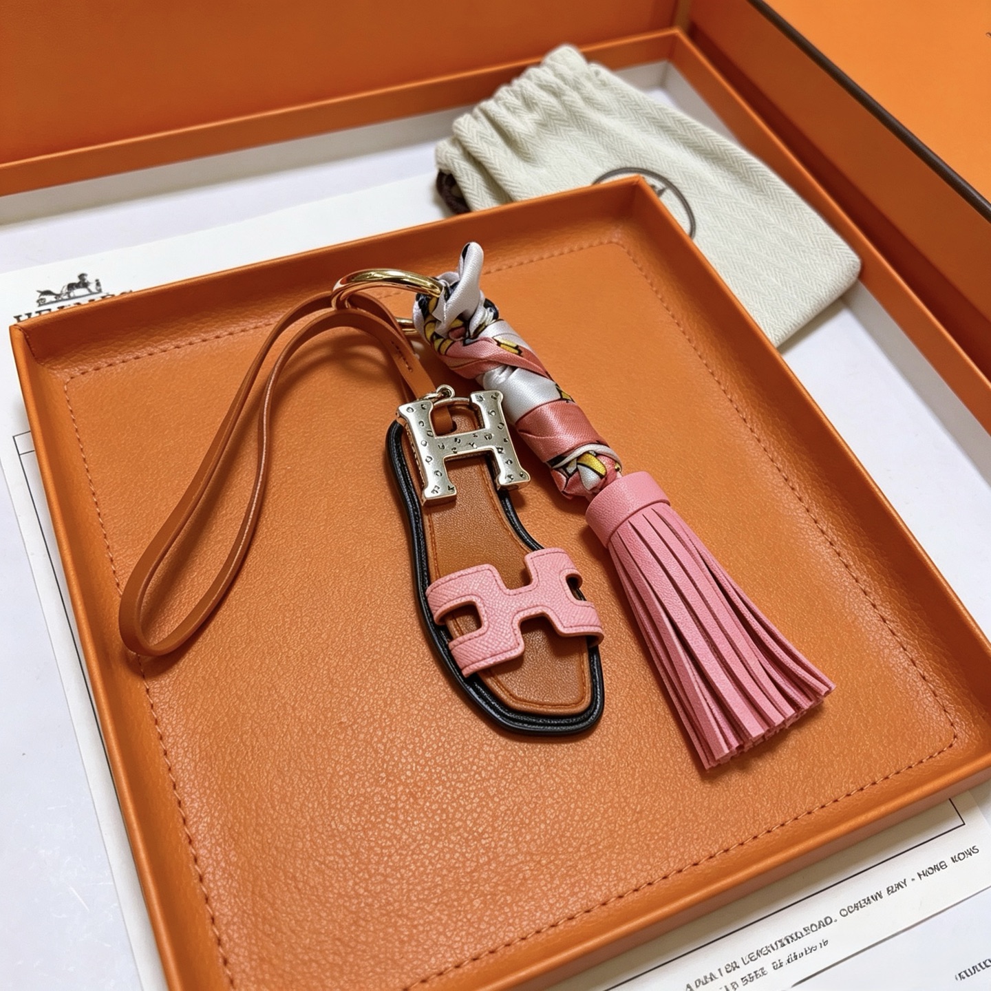 Hermes Oran Sandal Tassel Key Charm pendant Gold-tone metal silver-tone H hardware tan leather pink leather multicolor printed silk black edge trim 12cm total length