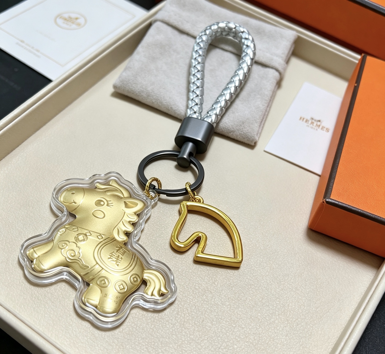 Hermes Cheval Horse Charm Porte-clés pendentif Breloque cheval en or mat accent de tête de cheval doré bracelet en cuir tressé argenté matériel noir en bronze à canon couvercle de charme de protection transparent 12 cm poignet tressé