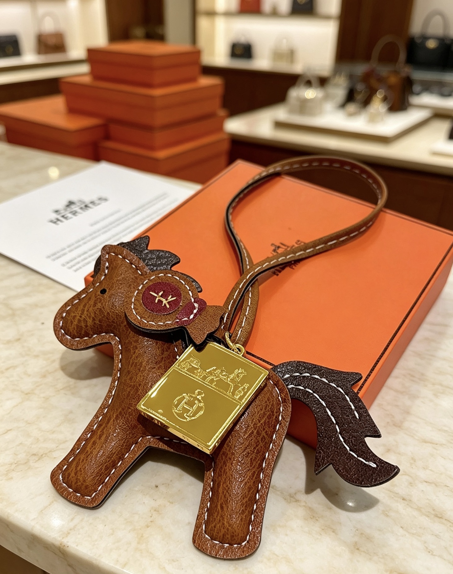 Ciondolo per borsa Hermes Rodeo Pegase Horse con pendente Ex-Libris in oro Pelle marrone in metallo color oro con coda di criniera marrone scuro accento in pelle bordeaux cuciture a contrasto bianche Lunghezza cinturino 12 cm