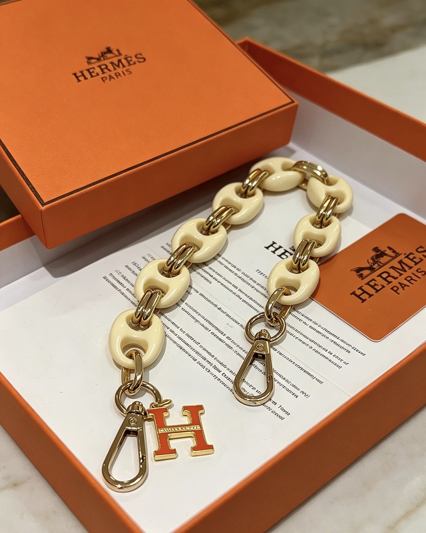 Hermes H Logo Bag Charm Chain pendentif Résine blanc crème métal doré émail orange 18cm