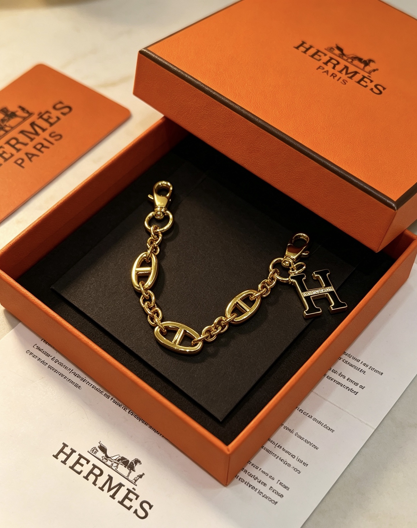 Hermes H Logo Chaine d Ancre Bag Charm Keychain pendant Gold-tone metal with black enamel and clear crystal accents 16cm