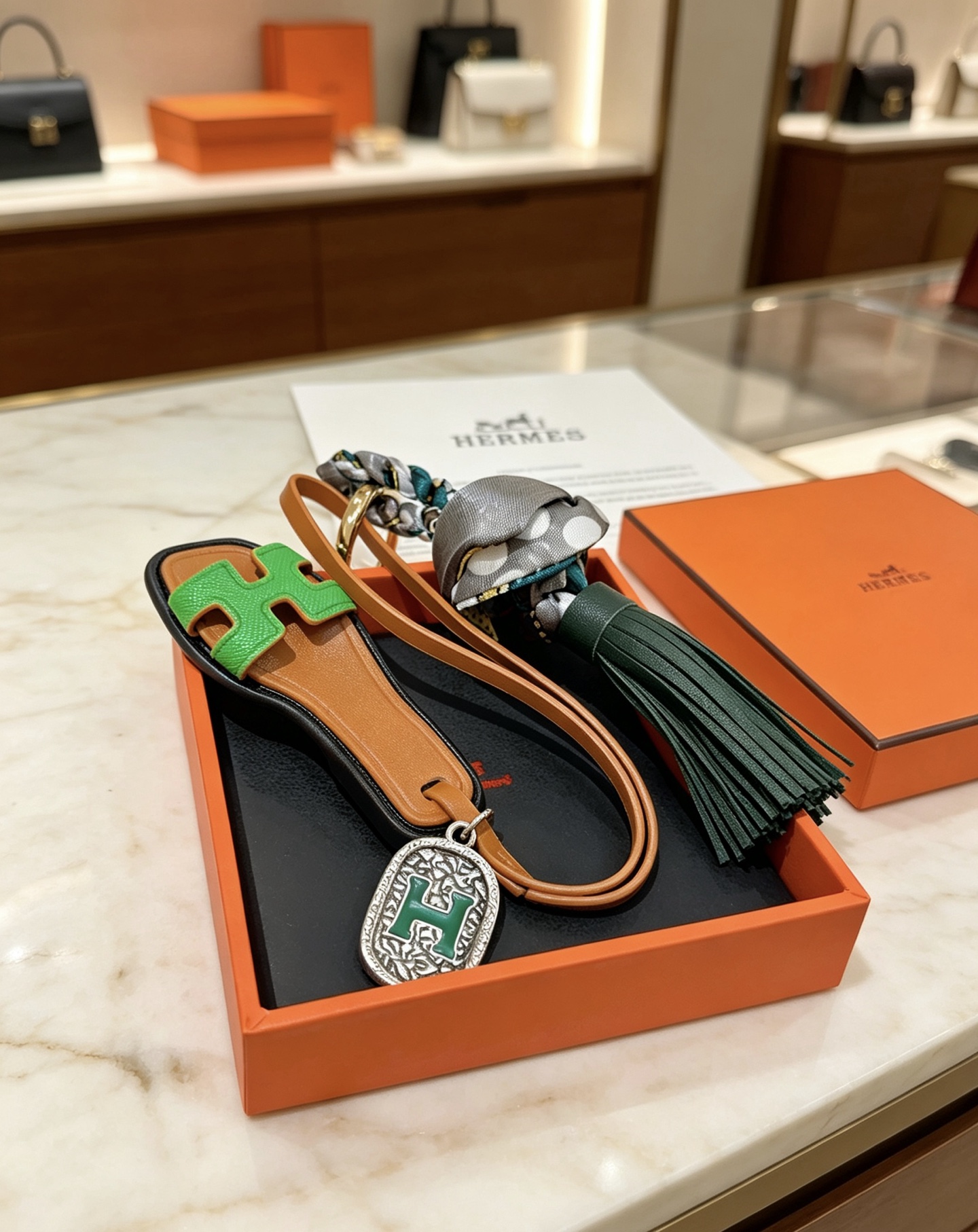 Hermes Oran Sandália Tassel Bag Pingente com pingente de metal dourado couro bronzeado couro verde brilhante couro verde escuro cinza bolinhas seda metal prateado com esmalte verde Detalhe H 12 cm de comprimento total