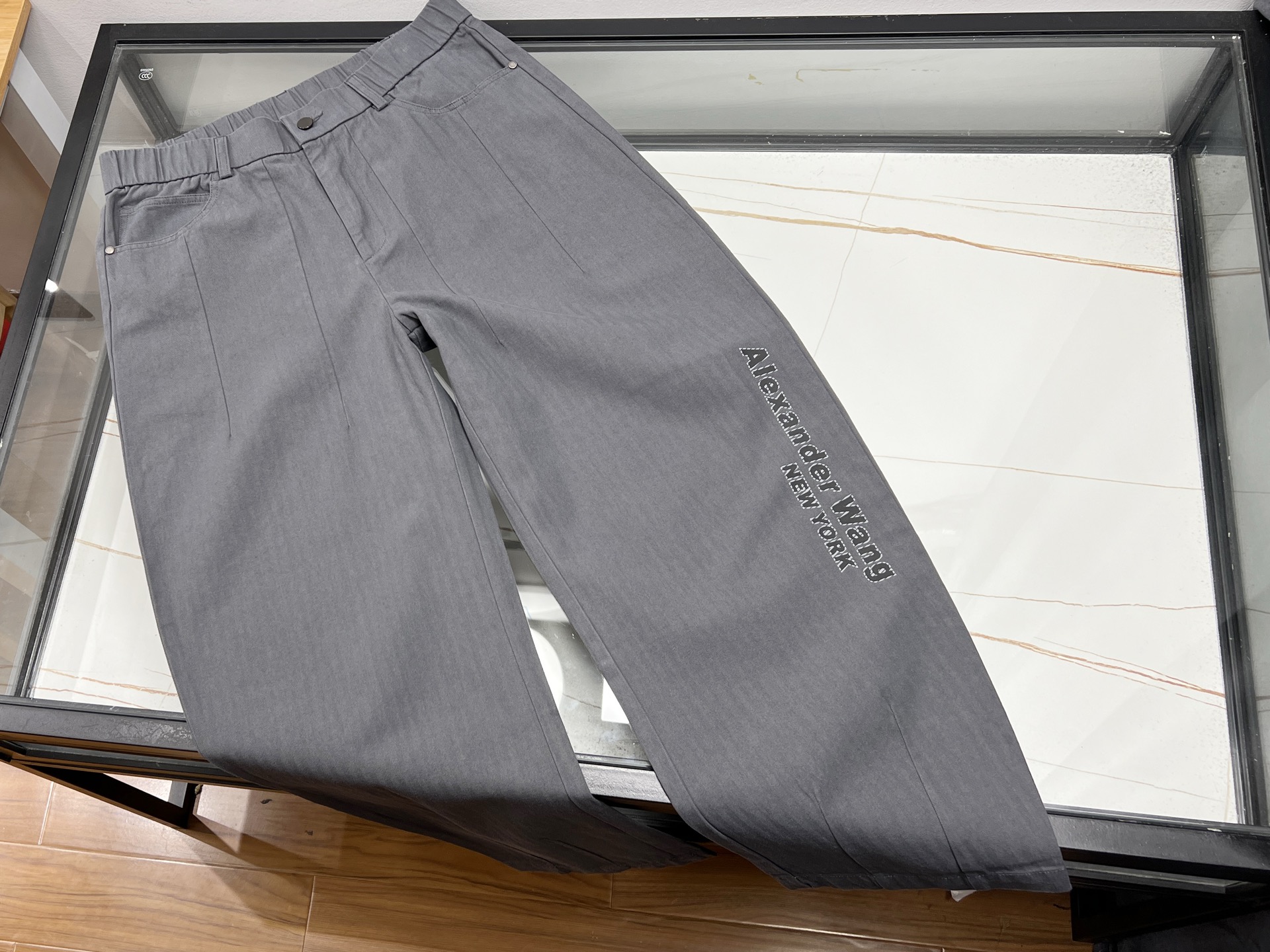 NO:637208,-25SS————Dawang texture letter pants have become a popular item in the fashion circle with their unique design and comfortable wearing experience. This series of pants is mostly made of high-quality fabrics, such as brushed cashmere or blended materials, which are soft to the touch and have good warmth retention, and are suitable for wearing in many seasons. Wear. Its iconic letter waist design is simple and fashionable, paired with contrasting lines or textured fabrics, which not only highlights your personality but does not lose its sense of luxury. In terms of style, the medium version or high-waisted straight design is highly tolerant and suitable for a variety of body types, especially pear-shaped figures, and has a significant slimming effect. In terms of details, some styles use 7A-grade mulberry silk antibacterial bottom crotch, taking into account health and comfort; the seamless design of the trouser legs or fine hemming technology improves the overall texture. Whether it is paired with a simple T-shirt or a fashionable top, it can be easily controlled to meet the needs of daily travel or leisure occasions. It is an ideal choice for those who pursue quality and fashion sense. Available in stock Dark gray XS-S-M-L, Alexander Wang-clothing, alexander wang, tees, t-shirt, alexander wang19860909-25SS————大王肌理字母裤以其独特的设计和舒适的穿着体验,成为时尚圈的热门单品.该系列裤子多采用高品质面料,如磨毛羊绒或混纺材质,触感柔软且保暖性佳,适合多季节穿着.其标志性的字母腰头设计简约时尚,搭配撞色线条或肌理感面料,既凸显个性又不失高级感.版型上,中版或高腰直筒设计包容性强,适合多种身材,尤其对梨形身材友好,显瘦效果显著. 细节方面,部分款式采用7A级桑蚕丝抗菌底裆,兼顾健康与舒适；裤脚无痕设计或精细收边工艺,提升整体质感.无论是搭配简约T恤还是时尚上衣,都能轻松驾驭,满足日常出行或休闲场合需求,是追求品质与时尚感人士的理想选择. 现货发售深灰XS-S-M-L,亚历山大王-服装,alexander wang,tees，t-shirt,alexander wang,Women's clothing