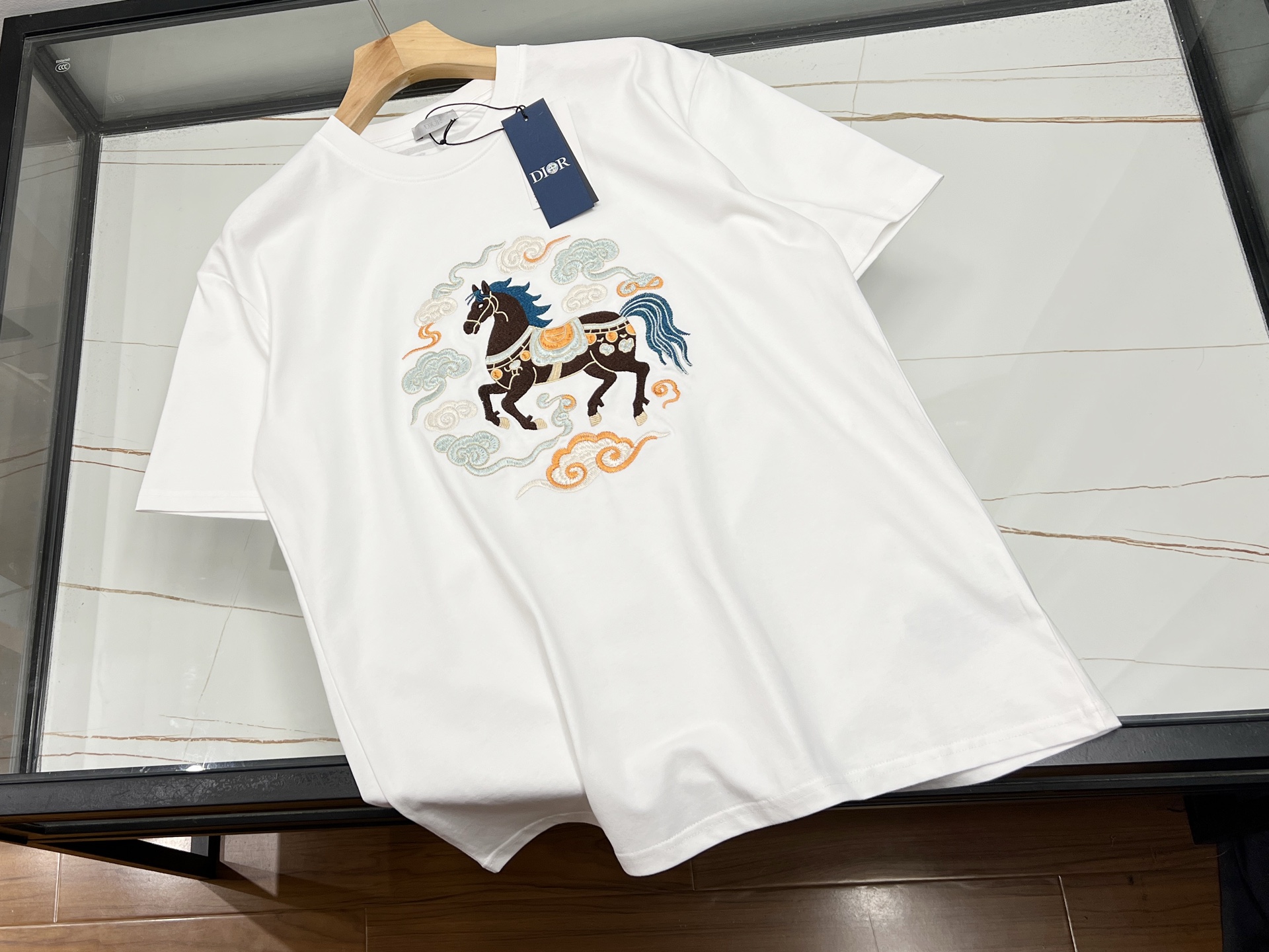 NO:660867,-26SS————In 2026, embroidered short-sleeves show a multi-innovation trend, deeply integrating traditional craftsmanship with modern design. In terms of pattern design, layered collage has become a highlight, such as the clever superposition of folk totems and abstract geometric figures to create a story-rich visual effect; artistic vine elements are also widely used, with winding lines growing freely on the clothing, creating a creative atmosphere.  Create a natural and lively atmosphere. In terms of embroidery technology, Jiahe's custom-developed hand-embroidery washing process makes embroidered short-sleeves more adaptable to modern life. In terms of style, there are new Chinese-style Hunan embroidery short-sleeves, which use delicate line drawing to outline the artistic conception and show oriental charm;  Ready to ship white S-XL, Dior-clothing, dior, miumiu, T-shirt,  19860909-26SS———2026年刺绣短袖呈现出多元创新趋势,将传统工艺与现代设计深度融合.在图案设计上,层次拼贴成为亮点,如将民俗图腾与抽象几何图形巧妙叠加,创造出富有故事性的视觉效果；艺术藤蔓元素也被广泛应用,蜿蜒的线条在服装上自由生长,营造出自然灵动的氛围.刺绣工艺上,迦禾定制研发的手工刺绣洗涤工艺,让刺绣短袖更适应现代生活.在风格上,既有新中式湘绣短袖,以细腻线描勾勒意境,展现东方韵味；也有Miu系短袖,通过不对称剪裁、独特印花,融合甜美与酷感,满足不同场合穿搭需求. 现货发货白色S-XL,迪奥-服装,dior,miumiu,T-shirt, ,Women's clothing