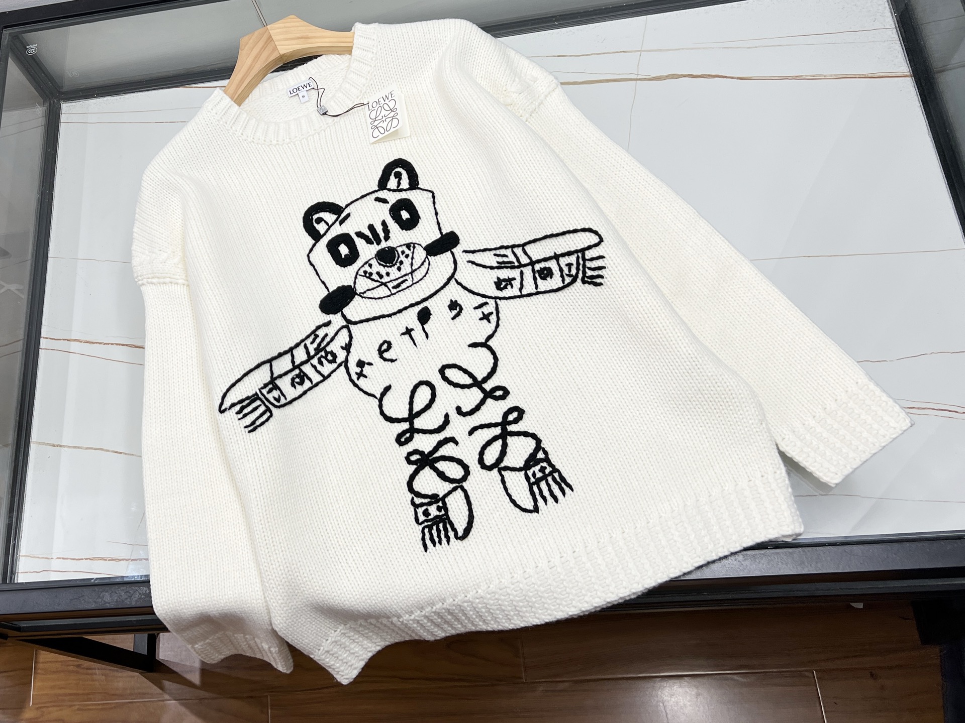 NO:660839,-25SS——Animal knitted woolen sweater for men and women, a duet of warmth and fashion. When delicate wool meets craftsmanship, an animal knitted woolen sweater for men and women is the soul of the autumn and winter wardrobe. Selected Australian merino wool feels like a gentle embrace of clouds.  The double-strand encrypted weaving technology doubles the thickness without looking bloated, and can maintain a chic posture even at minus 5 degrees Celsius. The high-neck design protects the temperature of the neck, and the silhouette tailoring hides the little secrets of the figure. It can be easily controlled whether it is a leisure time for a morning coffee run or an elegant occasion with dinner lights.  Oatmeal, caramel brown, and haze gray are three limited-edition autumn colors. They are like draping the colors of the fallen leaves on the body. Morandi's tonal splicing method adds an artistic touch. The three-dimensional cable texture breaks the monotony, and the side slits quietly lengthen the leg proportions. The careful attention to details makes basic styles look high-end. The iron-free material saves the morning commute. It can be crumpled into a ball and stuffed into the suitcase without wrinkles. It is a magical item for business trip parties.  What's even better is that this cardigan is designed with an oversize silhouette, which accommodates various body types, unlocking new ideas for couples' clothing. Available now in white S-XL, Loewe-clothing, loewe, versace,  19860909-25SS———动物针织羊毛衫男女同款,温暖与时尚的双重奏当细腻羊毛邂逅匠心工艺,一件男女同款的动物针织羊毛衫,便成了秋冬衣橱的灵魂单品.精选澳洲美利奴羊毛,触感如云朵轻拥,双股加密编织技术让厚度翻倍却不显臃肿,零下五度也能保持潇洒姿态.高领设计护住脖颈温度,廓形剪裁藏起身材小秘密,无论是晨跑咖啡的休闲时光,还是晚宴灯光的优雅场合,都能轻松驾驭. 燕麦色、焦糖棕、雾霾灰,三款秋日限定色,像把落叶季的颜色盘披在身上,莫兰迪色调拼接手法更添艺术气息.立体绞花纹理打破单调,侧边开叉悄悄拉长腿型比例,细节处的小心机,让基础款也能穿出高级感.免熨烫材质拯救通勤早晨,揉成团塞进行李箱也不皱,出差党狂喜的神仙单品. 更妙的是,这件羊毛衫采用oversize轮廓设计,包容各种体型差异,情侣装新思路就此解锁 现货发售白色S-XL,罗意威-服装,loewe,versace, ,Women's clothing