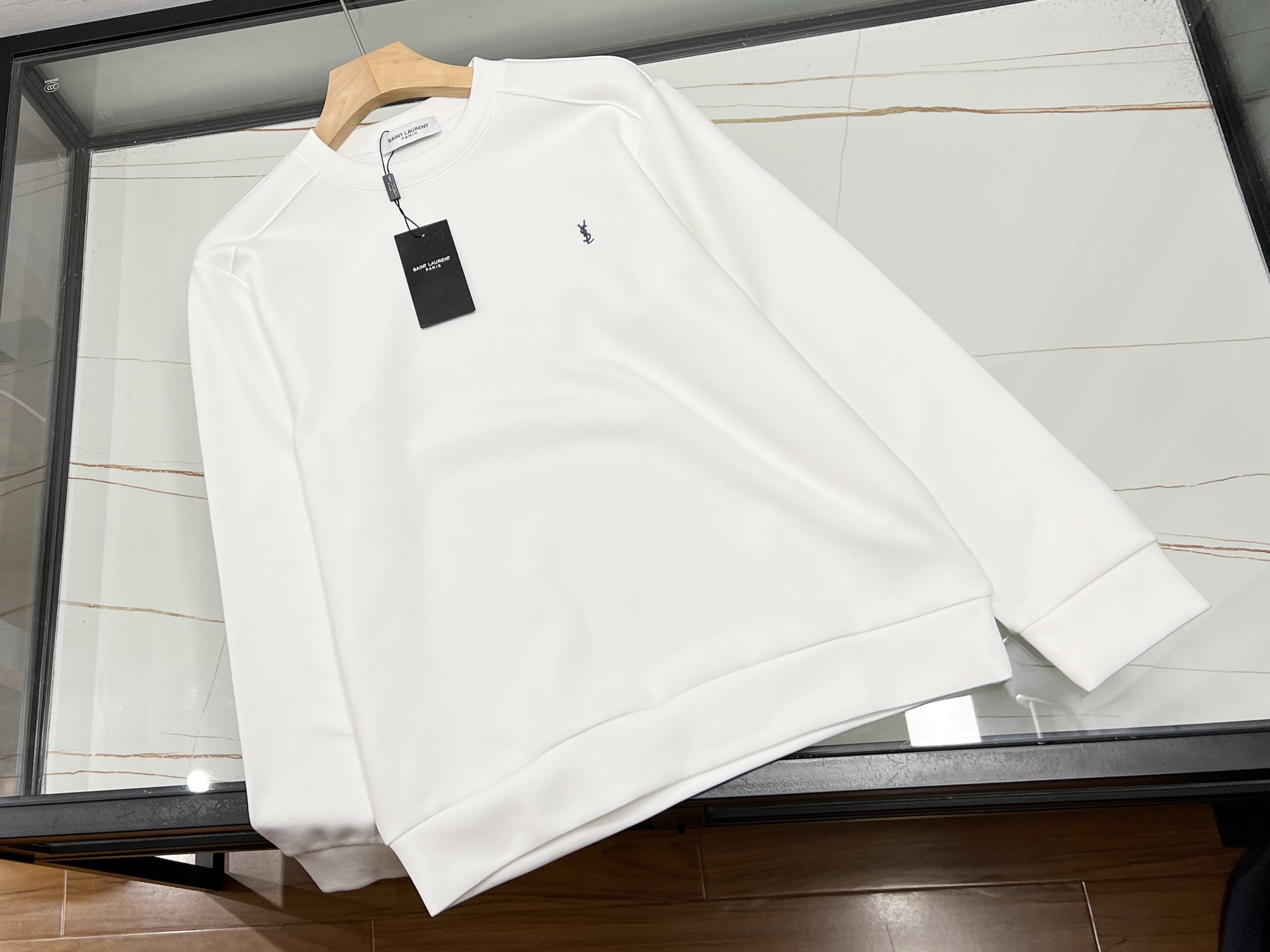 NO:677095,-25SS————In the autumn and winter of 2025, brushed three-dimensional shoulder sweatshirts have become the focus of fashion. They are made of fabrics treated with a special brushed process, which are as soft as clouds to the touch. They visually present a delicate texture and are 30% warmer than ordinary sweatshirts. The three-dimensional shoulder line design breaks through the laziness of traditional sweatshirts. Through precise cutting and arc splicing, a natural and crisp three-dimensional knot is formed on the shoulders.  The structure not only modifies the shoulder shape, but also injects a neat aura into the overall look. The dropped shoulder sleeves are combined with a loose fit to accommodate different body types, and the sides of the hem are often made of contrasting color splicing or irregular tailoring to break the monotony. Whether it is paired with high-waisted pants to create a 37/30 proportion, or layered with a coat to enhance the sense of layering, it can easily be used in many scenes such as commuting and leisure, making it a practical item for autumn and winter wardrobes.  Three colors S-XXL, Saint Laurent-clothing, saint laurent, hoodie, sweatshirts, available for sale now.19860909-25SS———2025年秋冬,拉毛立体肩卫衣成为时尚焦点.其采用特殊拉毛工艺处理的面料,触感柔软如云朵,视觉上呈现细腻肌理感,保暖性较普通卫衣提升30.立体肩线设计突破传统卫衣的慵懒感,通过精准裁剪与弧形拼接,在肩部形成自然挺括的立体结构,既能修饰肩型,又为整体造型注入利落气场.落肩袖与宽松版型结合,包容不同身材,下摆侧边常采用撞色拼接或不规则剪裁,打破单调.无论是搭配高腰裤打造三七分比例,还是叠穿大衣增强层次感,都能轻松驾驭通勤、休闲等多场景,成为秋冬衣橱的实穿单品. 现货发售三色S-XXL,圣罗兰-服装,saint laurent,hoodie,sweatshirts,,Women's clothing