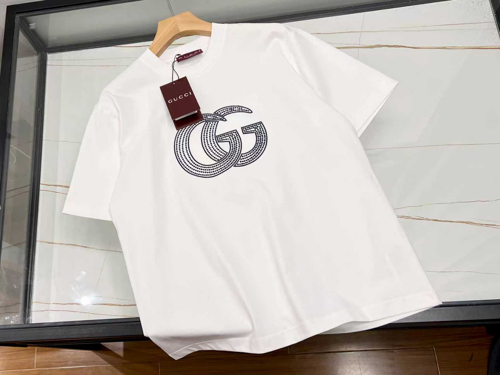 NO:711013,-26SS——Letter emblem pure cotton short-sleeve, a personalized choice for summer fashion. This letter emblem pure cotton short-sleeve is an indispensable fashion item in the summer wardrobe. The selected high-quality pure cotton fabric is soft to the touch and skin-friendly, and has excellent breathability. Even in the hot summer, it can allow the skin to breathe freely and stay dry and comfortable at all times.  The letter badge design on the clothes is unique and becomes the finishing touch of the overall look. It not only adds a trendy element to the simple short sleeves, but also shows a unique personality attitude. Whether you wear it with casual shorts for a stroll on the street or with jeans for a casual party, it can easily make you the center of attention, showing a casual and fashionable charm. Available in stock in two colors S-XL, Gucci-clothing, gucci, shorts, jeans, T-shirt,19860909-26SS——字母徽章纯棉短袖夏日时尚的个性之选 这件字母徽章纯棉短袖,是夏日衣橱里不可或缺的时尚单品.精选优质纯棉面料,触感柔软亲肤,透气性极佳,即便在炎炎夏日,也能让肌肤自由呼吸,时刻保持干爽舒适. 衣服上的字母徽章设计独具匠心,成为整体造型的点睛之笔.它不仅为简约的短袖增添了潮流元素,更彰显出独特的个性态度.无论是搭配休闲短裤漫步街头,还是配上牛仔裤出席轻松聚会,它都能让你轻松成为焦点,展现出随性又时尚的魅力. 现货发货二色S-XL,古驰-服装,gucci,shorts,jeans,T-shirt,,Women's clothing