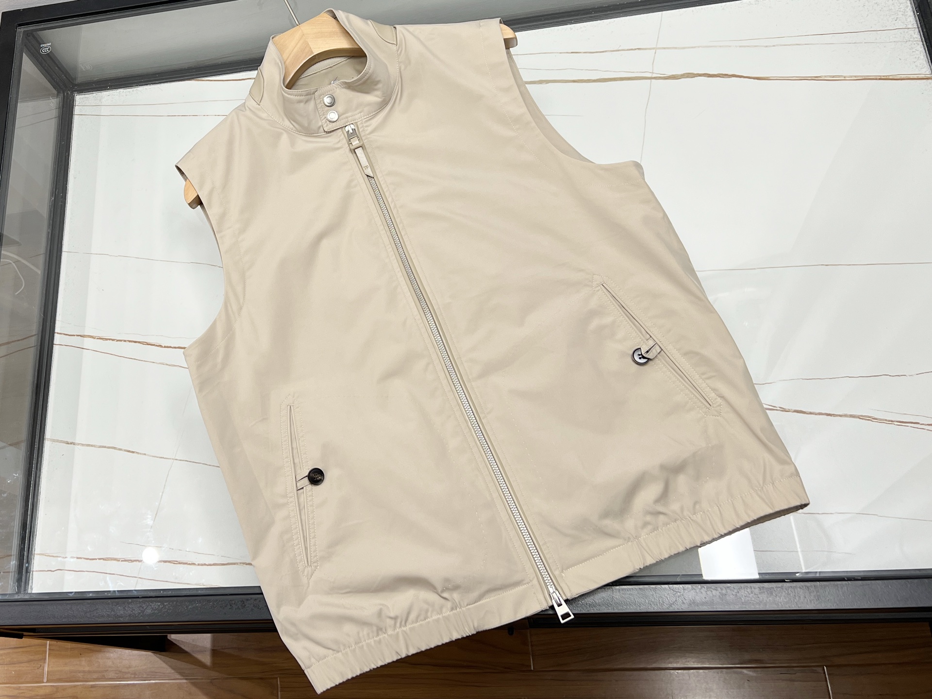 NO:720938,-26SS——TF Solona three-defense vest  This TF vest uses high-end fabrics and the brand's iconic craftsmanship, taking into account practical performance and exquisite style. It is a high-quality choice for multiple scenes. The stand-up collar design is neat and windproof, the placket is equipped with a double No. 5 zipper, and the iconic TF leather slider is matched with zipper woven leather.  Decorated with high-quality materials, the details show the texture. The outer fabric is made of DuPont Solona fiber, which has excellent horizontal elasticity, softness and anti-wrinkle. The surface has been treated with three-proof treatment, which is waterproof, oil-proof, stain-proof and easy to care for. The whole thing is sewn with British Coats thread, which is strong and durable. Fabric polyester fiber, lining  The sword and scalp tabs on the back collar are highly recognizable, and the pockets on both sides are curved and hand-made arched with horn buttons. The mesh fabric is light and breathable. In business settings, it can be layered with singlets to create an elite look. It can be paired with T-shirts and jeans for daily use, adapting to a variety of dressing needs. Available in stock in two colors 48-50-52-54-56, men's clothing, tom ford, jeans, tees, t-shirt,19860909-26SS——TF 索罗娜三防马甲 本款TF马甲甄选高端面料与品牌标志性工艺,兼顾实用性能与精致格调,是多场景穿搭的优质之选.立领设计利落防风,门襟配双开5号拉链,标志性TF皮拉头搭配拉链织边皮质装饰,细节尽显质感.外层面料采用杜邦索罗娜纤维,自带优异横弹,柔软抗皱,表面经三防处理,防水防油防污易打理；全件用英国高士线缝制,牢固耐用.面料聚酯纤维、里料 后领宝剑头皮袢辨识度拉满,两侧挖袋弧形手工拱针配牛角纽扣,网布里布轻盈透气.商务场景可叠穿单西打造精英造型,日常搭配T恤牛仔裤即可,适配多元穿搭需求. 现货发售二色48-50-52-54-56,男装,tom ford,jeans,tees，t-shirt,,Women's clothing