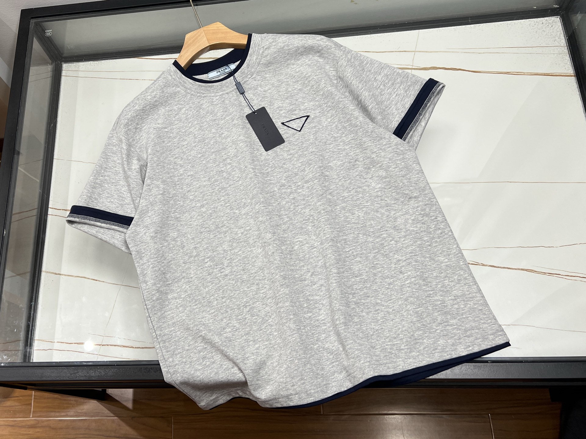 NO:774223,-26SS——Triangle logo double-sided heavy-duty washed short-sleeves combine trendy design and exquisite craftsmanship, showing a unique retro street style. Made of heavyweight pure cotton fabric (240-320g thickness), after double washing process, the clothes have a natural aged texture, soft to the touch and good breathability, making the wearing experience comfortable and not sweaty. The iconic metal triangle logo is decorated on the chest, adding exquisite highlights to the simple version, with double-sided heavy-duty stitching details to enhance the overall three-dimensional sense of hierarchy.  Designed with both practicality and fashion in mind, the loose cut is suitable for a variety of body shapes and can be worn with high-waisted pants or casual skirts. The washing process ensures that the clothes will not deform easily after being worn for a long time, and the traceless printing technology allows the pattern to remain bright after multiple washes. Similar products on the market currently provide multi-color options to meet the needs of different body types. Whether it is for daily outings or mixed and matched, it can easily create a lazy yet personalized look, making it a versatile item for the spring and summer wardrobe.  Three colors S-XL, Prada-clothing, prada, skirts, T-shirt, available for sale now.19860909-26SS———三角标双面重工水洗短袖融合了潮流设计与精湛工艺,展现出独特的复古街头风格.采用重磅纯棉面料（240-320g厚度）,经过双重水洗工艺处理,衣物呈现自然做旧质感,触感柔软且透气性佳,穿着体验舒适不闷汗.标志性的金属三角徽标装饰于胸口,为简约版型增添精致亮点,搭配双面重工缝线细节,提升整体立体层次感. 设计上兼顾实用与时尚,宽松剪裁适配多种身形,可搭配高腰裤或休闲裙装.水洗工艺确保衣物久穿不易变形,无痕印花技术使图案经多次洗涤仍保持鲜艳.目前市场同类产品提供多色选择,,满足不同体型需求.无论是日常出街还是混搭叠穿,都能轻松打造慵懒又不失个性的造型,成为春夏衣橱的百搭单品. 现货发售三色S-XL,普拉达-服装,prada,skirts,T-shirt,,Women's clothing