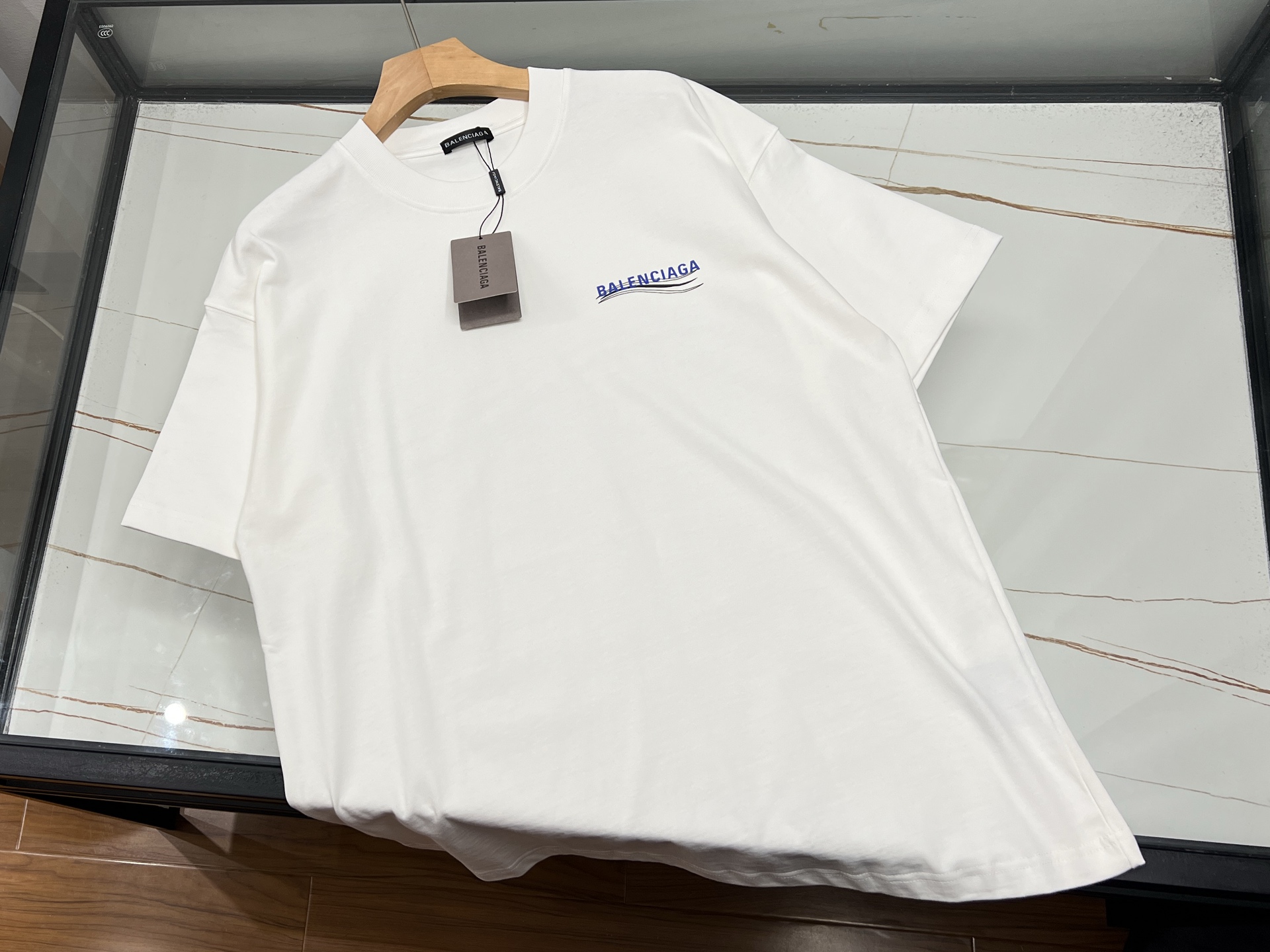 NO:774212,-26SS - Heavy-duty washed short-sleeves with letters on the chest perfectly integrate retro craftsmanship and modern trends. They are made of 320g heavy-weight pure cotton fabric and are treated with double washing processes to present a natural aged texture and soft touch. The iconic strip design uses double-sided heavy-duty sewing technology, and the stripe spacing is precisely calculated to modify the body shape and full of visual tension. Classic color schemes such as black and gray/blue and white meet different style needs.  The details reflect the ingenuity of the three-needle reinforced neckline to ensure that it does not deform, the double-stitched cuffs improve durability, and the slightly dropped shoulder tailoring combines comfort and silhouette. The special washing process gives the clothes a retro charm while keeping the fabric stiff and not easily deformed. It is highly malleable in terms of matching, whether it is paired with overalls to create a street style, or combined with denim items to give an American retro feel, it can be easily controlled. The loose-fitting design is suitable for layering, and is a must-have item for trendy people who pursue texture and personality.  Ready for sale black/white S-XL, Balenciaga-clothing, balenciaga, T-shirt,19860909-26SS——胸前字母重工水洗短袖将复古工艺与现代潮流完美融合,采用320g重磅纯棉面料,经过双重水洗工艺处理,呈现出自然的做旧质感与柔软触感.标志性的间条设计采用双面重工缝制技术,条纹间距经过精密计算,既能修饰身形又充满视觉张力,黑灰/蓝白等经典配色方案满足不同风格需求. 细节处体现匠心三本针加固领口确保不变形,双车线袖口提升耐用性,微落肩剪裁兼顾舒适与廓形感.特殊的水洗工艺使衣物自带复古韵味,同时保持面料挺括不易变形.搭配方面极具可塑性,无论是搭配工装裤打造街头风,还是与牛仔单品组合呈现美式复古感,都能轻松驾驭.宽松版型设计适合叠穿,是追求质感与个性的潮流人士必备单品. 现货发售黑色/白色S-XL,巴黎世家-服装,balenciaga,T-shirt,,Women's clothing