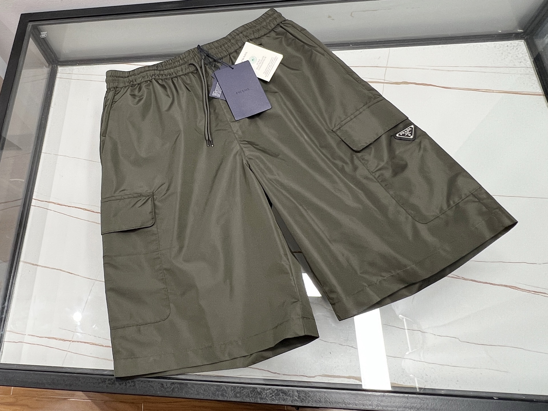 NO:776853,-26SS——Quick-drying pocket casual pants, a must-have item for summer travel!  It uses high-tech quick-drying fabric, which can quickly absorb and evaporate sweat, keeping the body dry and comfortable, and you can enjoy coolness even in the hot summer. The trousers are designed with multiple practical pockets, which are convenient for storing mobile phones, wallets and other small items, allowing your hands to be completely freed. The mid-length trousers are tailored to fit and are not too big.  It is not tight but not bloated, showing a casual yet fashionable style. Whether it is outdoor sports, daily travel or casual gatherings, it can be easily controlled, making you confident in any occasion. Choose these quick-drying pocket casual pants to make your summer life more convenient, comfortable and colorful!  Ready for sale in two colors S-XL, Prada-clothing, prada, wallets,19860909-26SS———速干口袋休闲中裤,夏日出行必备神器！它采用高科技速干面料,能迅速吸收并挥发汗水,保持身体干爽舒适,即使炎炎夏日也能畅享清凉.裤身设计有多个实用口袋,方便存放手机、钱包等小物件,让你的双手彻底解放.中裤版型剪裁合身,既不过于紧绷也不显臃肿,展现出休闲而不失时尚的风格.无论是户外运动、日常出行还是休闲聚会,它都能轻松驾驭,让你在任何场合都能自信满满.选择这款速干口袋休闲中裤,让你的夏日生活更加便捷、舒适与多彩！ 现货发售二色S-XL,普拉达-服装,prada,wallets,,Women's clothing