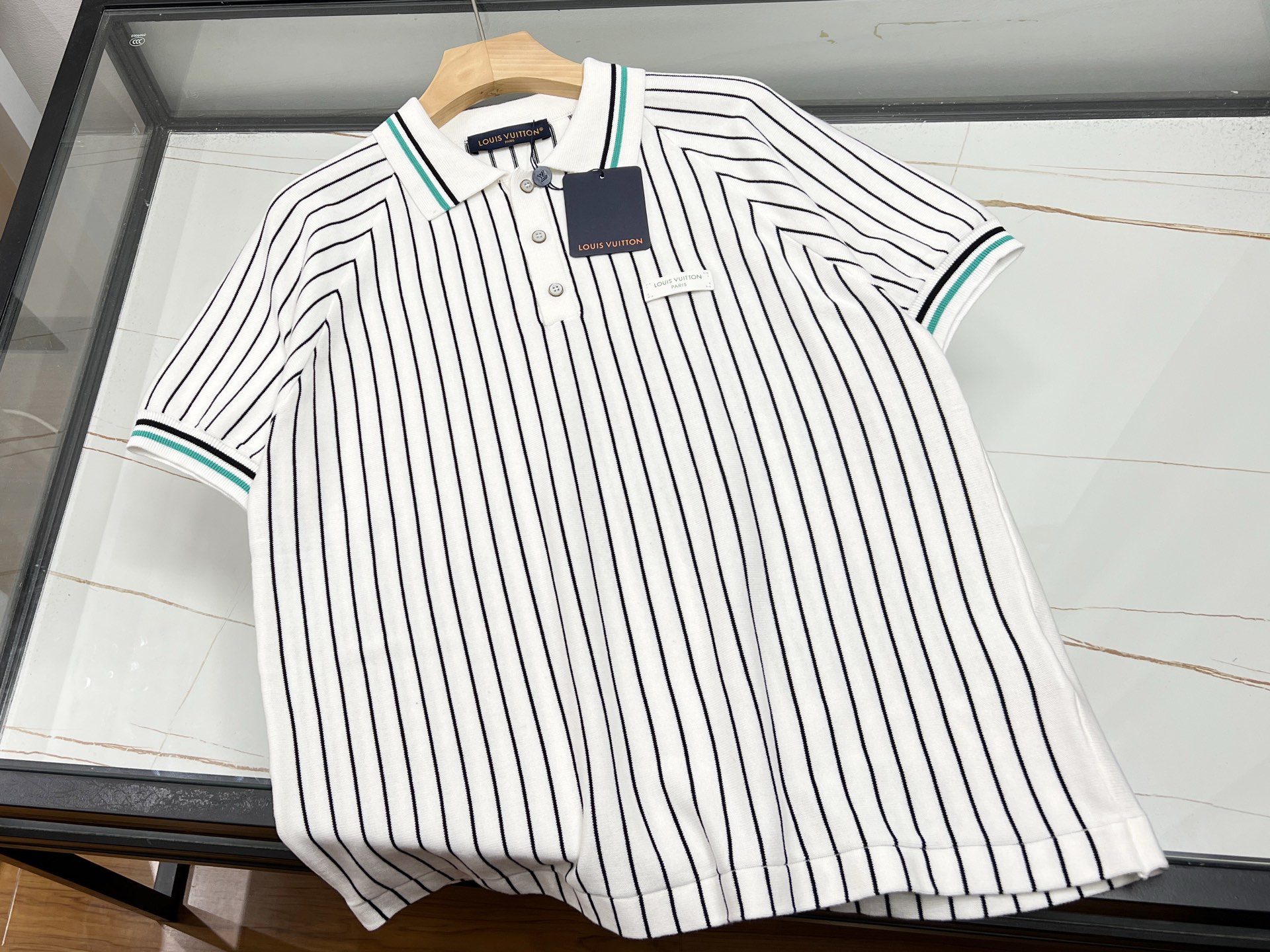 NO:784331,-26SS————In the summer of V, knitted striped short-sleeves have become a must-have item in the wardrobe with the fusion of classic and fashion. It is made of high-elastic blended fabric, which combines the breathability of cotton and the cool feeling of linen. It is soft and skin-friendly, and will not be stuffy when worn for a long time. It has been treated with three times of color fixing process and is not easy to fade and deform after machine washing. In terms of design, the narrow stripes extend vertically and have a significant slimming effect. The loose fit accommodates fat on the waist and abdomen, and the round neck or V-neck design modifies the neck line. Some styles add chain decoration or hollow elements to break the monotony. Pair it with high-waisted jeans or skirts to easily switch between commuting and dating scenes. Soft colors such as cream white and navy blue are suitable for a variety of skin colors. They are both practical and fashionable, making them an ideal choice for both sophisticated and casual styles this summer. In stock, S-XL, Louis Vuitton-clothing, Louis Vuitton, skirts, jeans, T-shirt,19860909-26SS———V年夏季,针织间条短袖以经典与时尚的融合成为衣橱必备单品.采用高弹混纺面料,融合棉的透气性与麻的清凉感,触感柔软亲肤,久穿不闷热,且经三遍固色工艺处理,机洗不易褪色变形.设计上,细窄条纹纵向延伸视觉,显瘦效果显著,宽松版型包容腰腹赘肉,圆领或V领设计修饰颈部线条,部分款式加入链条装饰或镂空元素,打破单调感.搭配高腰牛仔裤或半身裙,轻松切换通勤、约会场景,奶油白、藏青等柔和色调适配多种肤色,实穿性与时尚感兼具,成为今夏轻熟风与休闲风的理想选择. 现货发货间条S-XL,路易威登-服装,louis vuitton,skirts,jeans,T-shirt,,Women's clothing