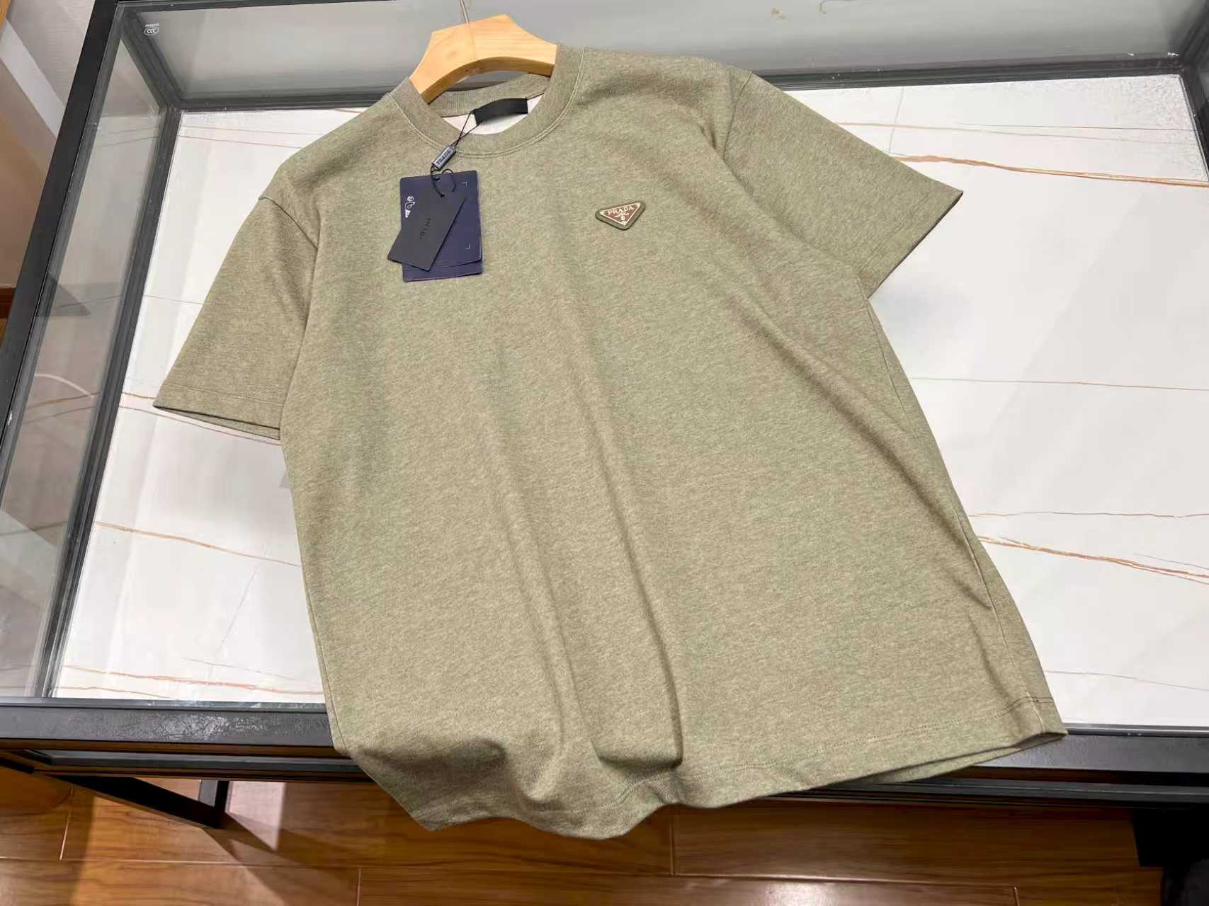 NO:784364,-26SS  ——P washed pure cotton fashionable casual men's and women's short-sleeves, based on natural pure cotton, treated with a special washing process, the fabric is soft and skin-friendly, and has excellent breathability. It is refreshing and not stuffy to wear in summer. The simple and loose version design accommodates different body shapes. The same style for men and women can be easily controlled, creating a casual and casual style. The classic round neck is neatly cut and fits the neck line; it falls  The shoulder sleeve design weakens the shoulder lines, making it more lazy and casual. The washing process gives the clothes a natural aged feel, and when paired with solid colors or simple prints, it exudes a high-end texture in a low-key manner. Whether paired with jeans, shorts or sports pants, it can be easily adapted to daily commuting, shopping and dating, or at home. It is an indispensable and versatile item in the spring and summer wardrobe, combining comfort and fashion.  Ready to ship; green S-XL, Prada-clothing, prada, shorts, jeans, T-shirt,19860909-26SS ———P水洗纯棉时尚休闲男女短袖,以天然纯棉为基底,经特殊水洗工艺处理,面料柔软亲肤,透气性极佳,夏日穿着清爽不闷热.简约宽松版型设计,包容不同身形,男女同款轻松驾驭,打造随性自在的休闲风格.经典圆领剪裁利落,贴合颈部线条；落肩袖设计弱化肩部线条,更显慵懒随性.水洗工艺赋予衣物自然做旧感,搭配纯色或简约印花,低调中透出高级质感.无论是搭配牛仔裤、短裤还是运动裤,都能轻松适配日常通勤、逛街约会或居家场景,是春夏衣橱里不可或缺的百搭单品,舒适与时尚兼具. 现货发货；绿色S-XL,普拉达-服装,prada,shorts,jeans,T-shirt,,Women's clothing