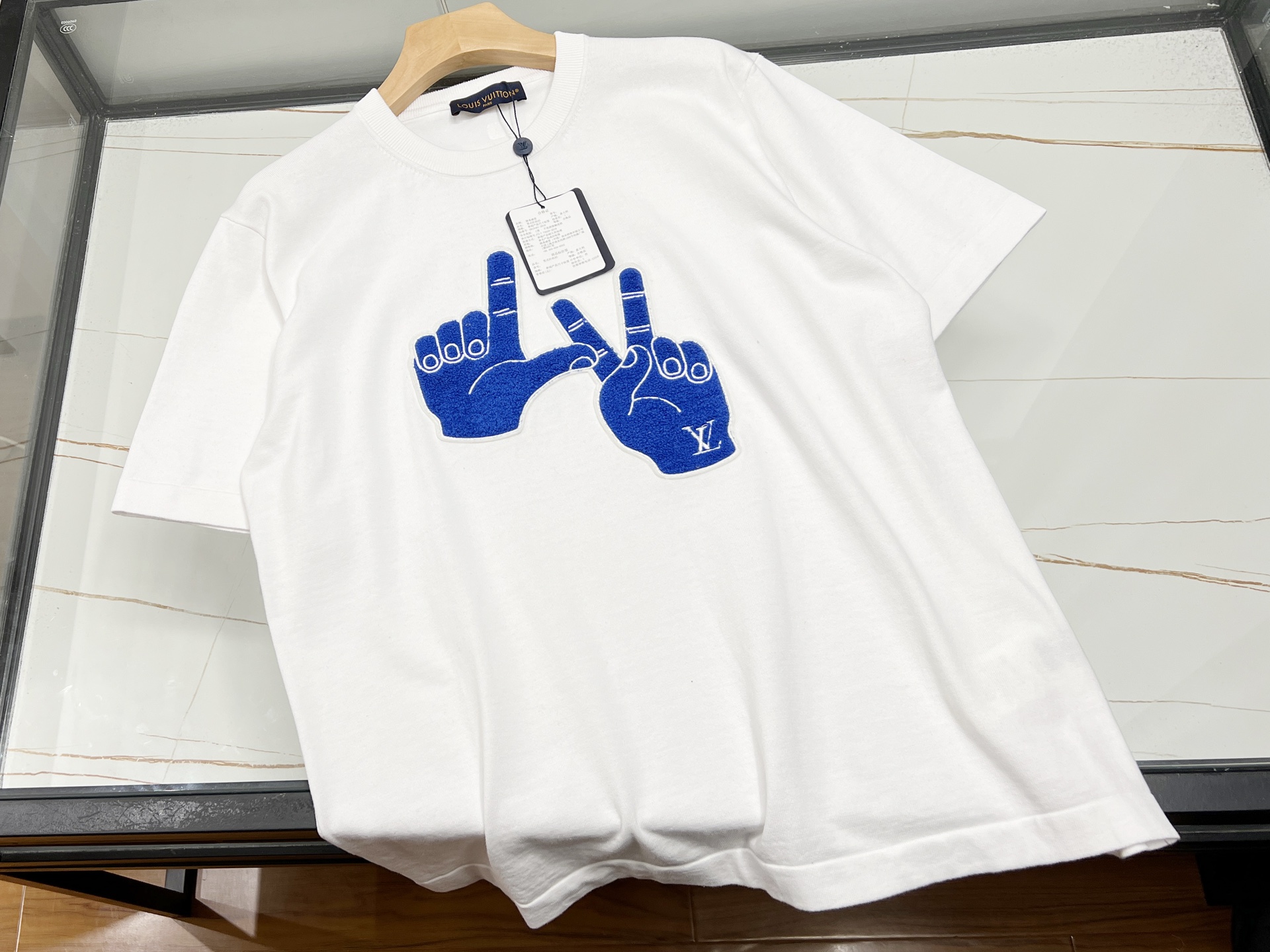 NO:786088,——26SS——V letter gesture knitted short-sleeves collide with fashion and personality. Letter gesture knitted short-sleeves are undoubtedly unique in this summer’s fashion world. It cleverly integrates letter elements and gesture patterns, and is presented with knitting technology. The texture is soft and skin-friendly, and it is comfortable to wear next to the body.  The short-sleeved design is simple yet individual, and the combination of letters and hand gestures is full of creativity, as if telling a unique fashion attitude. Whether it is a daily outing, a gathering of friends, or leisure sports, it can be easily adapted and adds highlights to the overall look. Paired with jeans, it is casual and free; paired with a short skirt, it is playful and cute. Wear it, you will be the most dazzling fashionista in the crowd, easily show off your own style, and start a vibrant summer journey. Available now in white S-XL, Louis Vuitton-clothing, louis  vuitton,skirts,jeans,T-shirt,19860909——26SS——V字母手势针织短袖时尚与个性碰撞 字母手势针织短袖,无疑是今夏时尚界的独特存在.它将字母元素与手势图案巧妙融合,以针织工艺呈现,质感柔软又亲肤,贴身穿也舒适自在. 短袖的设计简约而不失个性,字母与手势的组合充满创意,仿佛在诉说着独特的时尚态度.无论是日常出街、朋友聚会,还是休闲运动,它都能轻松适配,为整体造型增添亮点.搭配牛仔裤,随性又洒脱；配上短裙,俏皮又可爱.穿上它,你就是人群中最耀眼的时尚达人,轻松展现自我风格,开启活力满满的夏日之旅. 现货发售白色S-XL,路易威登-服装,louis vuitton,skirts,jeans,T-shirt,,Women's clothing