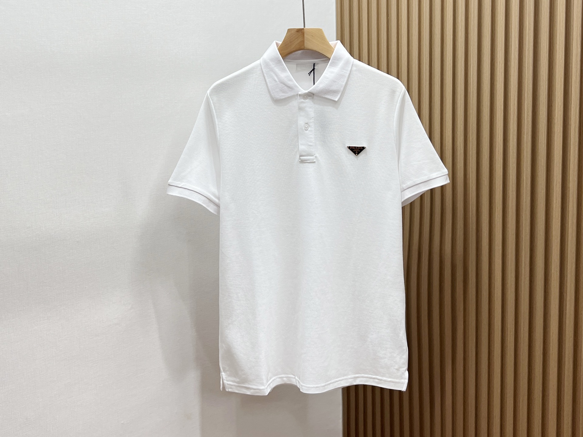 NO:819071,-26SS——P Triangle logo fashionable lapel short sleeves unlock the summer trend code. This triangle logo fashionable lapel short sleeves is an eye-catching artifact for the summer wardrobe. The classic lapel design is neat and capable, cleverly modifying the neck line, adding a sense of sophistication to the overall shape. The unique triangle logo element on the chest is individual and eye-catching, instantly breaking the monotony and highlighting the unique fashion taste. The short-sleeved style is refreshing and breathable, bringing the slightest coolness in the hot summer.  The fabric is soft and skin-friendly, comfortable and comfortable to wear, and there is no sense of restraint in activities. Whether paired with casual shorts, strolling on the streets, enjoying leisure time; or paired with suit trousers, attending relaxed business occasions, it can be easily controlled, allowing you to stay fashionable and confident at all times, becoming the focus of the crowd. Available in stock in two colors S-XL, Prada-clothing, prada, shorts, T-shirt, business suit,19860909-26SS———P三角标时尚翻领短袖解锁夏日潮流密码 这款三角标时尚翻领短袖,是夏日衣橱的吸睛神器.经典翻领设计,利落又干练,巧妙修饰颈部线条,为整体造型增添一份精致感. 胸前独特的三角标元素,个性又吸睛,瞬间打破单调,彰显独特时尚品味.短袖款式,清爽透气,在炎炎夏日带来丝丝凉意. 面料柔软亲肤,穿着舒适自在,活动毫无束缚感.无论是搭配休闲短裤,漫步在街头,享受悠闲时光；还是配上西装长裤,出席轻松的商务场合,它都能轻松驾驭,让你时刻保持时尚与自信,成为人群中的焦点. 现货发售二色S-XL,普拉达-服装,prada,shorts,T-shirt,business suit,,Women's clothing
