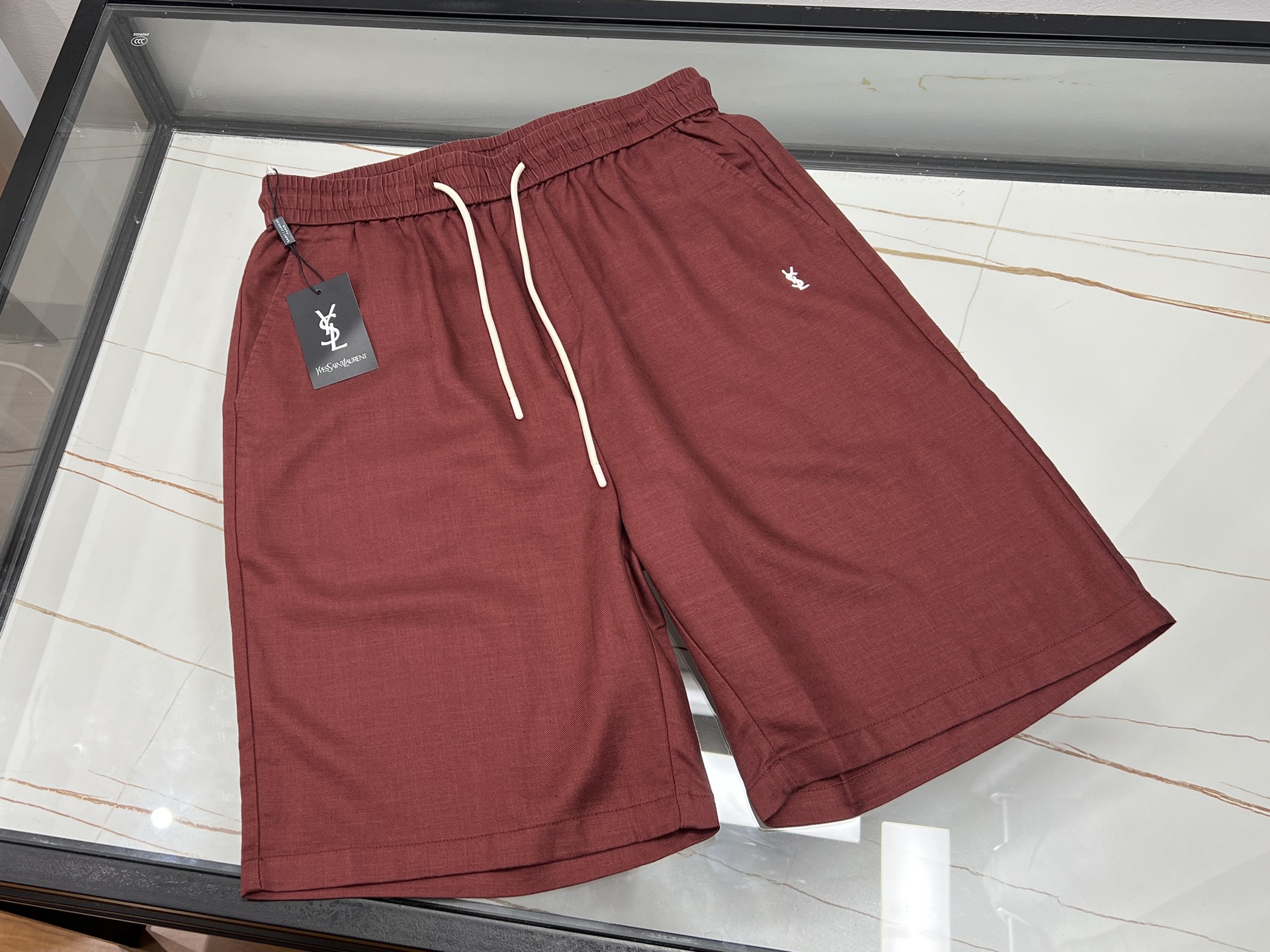 NO:820497,-26SS————SLP letter embroidered casual pants, unlocking casual summer fashion. These letter embroidered casual pants are a treasure item in the summer wardrobe. The overall lines of the pants are neat and smooth, and the length of the pants is just right. It is cool and neat, and there is no sense of restraint when moving.  The most eye-catching thing is undoubtedly the exquisite letter embroidery. The stitching is delicate and the letters are three-dimensional and full, which adds personality and artistic touch to the simple pants. The fabric is skin-friendly and breathable, soft and comfortable to wear next to the body, and has good sweat absorption, keeping you dry even in the hot summer.  In terms of matching, it can be called a 'universal match'. Paired with a simple white T, it is refreshing and youthful; paired with a printed shirt, it is full of fashion; paired with a pair of casual sneakers, you can easily create a street trend, whether it is daily outings or sports and fitness, it can make you comfortable and fashionable. Available in stock burgundy XS-S-L, Saint Laurent-clothing, loro piana, saint laurent, sneakers, shirts,19860909-26SS———SLP字母刺绣休闲中裤,解锁夏日随性时尚 这条字母刺绣休闲中裤,是夏日衣橱的宝藏单品.裤身整体线条利落流畅,中裤长度恰到好处,既凉爽又显利落,活动起来毫无束缚感. 最吸睛的当属那精致的字母刺绣,针法细腻,字母立体饱满,为简约的裤子增添了个性与艺术感.面料亲肤透气,贴身穿柔软舒适,吸汗性佳,即使夏日炎炎也能保持干爽. 搭配上,它堪称“万能搭子”.配简约白T,清爽又青春；搭印花衬衫,时尚感拉满；配上一双休闲运动鞋,轻松打造街头潮流风,无论是日常出街还是运动健身,都能让你自在又时髦. 现货发售酒红XS-S-L,圣罗兰-服装,loro piana,saint laurent,sneakers,shirts,,Women's clothing