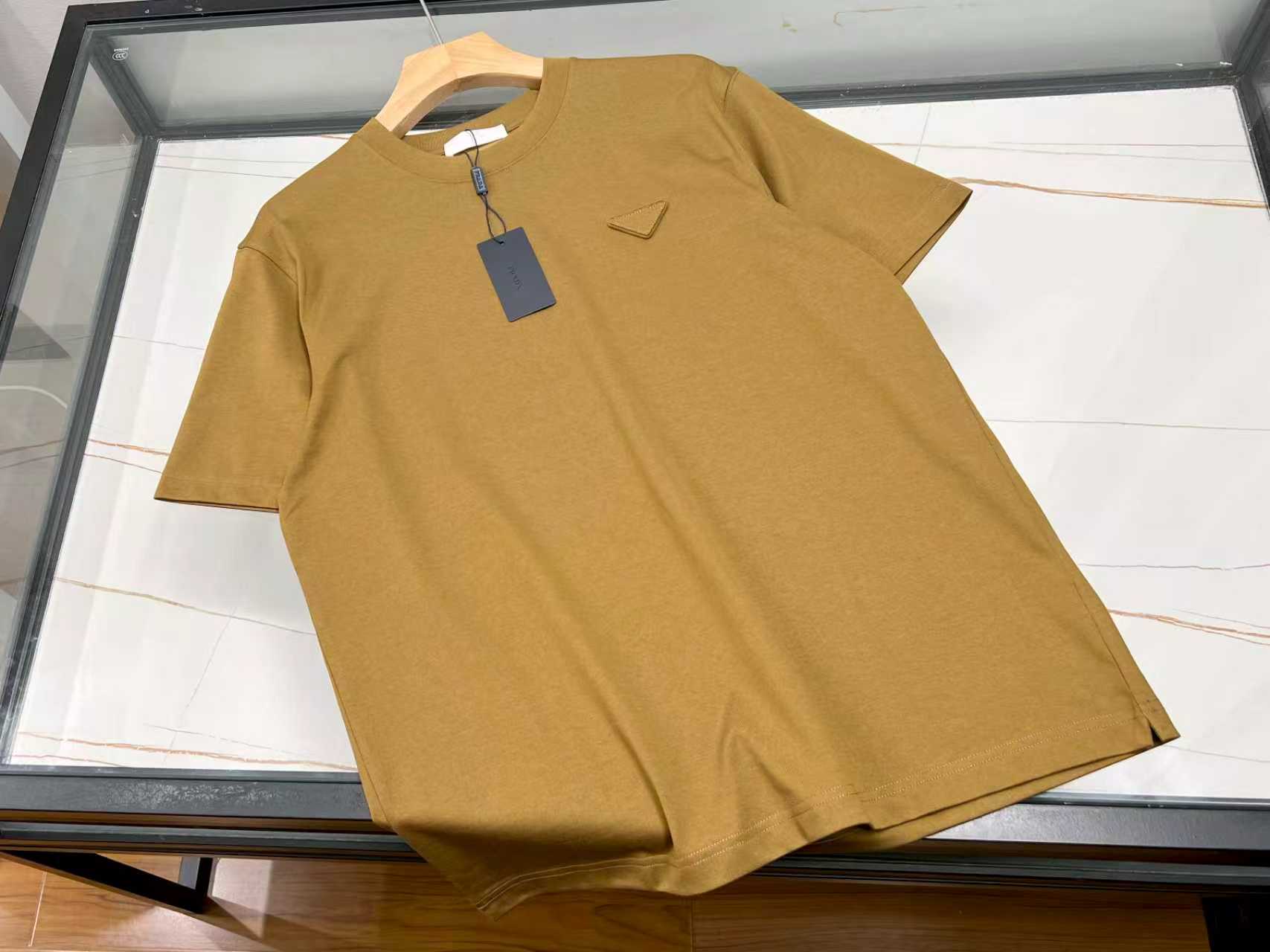 NO:820489,-26SS——P cloth label fashionable casual short sleeves, unlocking a new trend in summer wear. This cloth label fashionable casual short sleeves is undoubtedly a treasure item in the summer wardrobe. It is made of high-quality fabrics, feels soft and skin-friendly, and has excellent breathability, allowing the skin to breathe freely, even under the scorching sun, keeping it dry and comfortable at all times.  The unique design is one of its highlights. The exquisite cloth label decoration on the chest adds a sense of trend and personality to the whole, instantly breaking the monotony. The loose version is not flattering on the body shape. Whether you are slim or slightly fat, you can easily control it and show your leisure and freedom.  The simple solid color style is versatile and practical. It can be paired with jeans for youthful vitality; paired with casual shorts, it is refreshing and casual; paired with sports pants, it is dynamic. Whether it is daily outings, friends gatherings or sports and fitness, it is your best choice, allowing you to easily become the focus of the crowd. Ready for sale M-XXXL, Prada-clothing, prada, shorts, jeans, T-shirt,19860909-26SS———P布标时尚休闲短袖,解锁夏日穿搭新风尚 这款布标时尚休闲短袖,无疑是夏日衣橱里的宝藏单品.它精选优质面料,触感柔软亲肤,透气性绝佳,即便在炎炎烈日下,也能让肌肤自由呼吸,时刻保持干爽舒适. 独特的设计是它的一大亮点,胸前精致的布标装饰,为整体增添了几分潮流感与个性范儿,瞬间打破单调.宽松的版型不挑身材,无论是苗条身姿还是微胖体型,都能轻松驾驭,尽显休闲自在. 简约的纯色款式,百搭又实用,搭配牛仔裤,青春活力；搭配休闲短裤,清爽随性；搭配运动裤,动感十足.无论是日常出街、朋友聚会还是运动健身,它都是你的绝佳选择,让你轻松成为人群中的焦点. 现货发售M-XXXL,普拉达-服装,prada,shorts,jeans,T-shirt,,Women's clothing