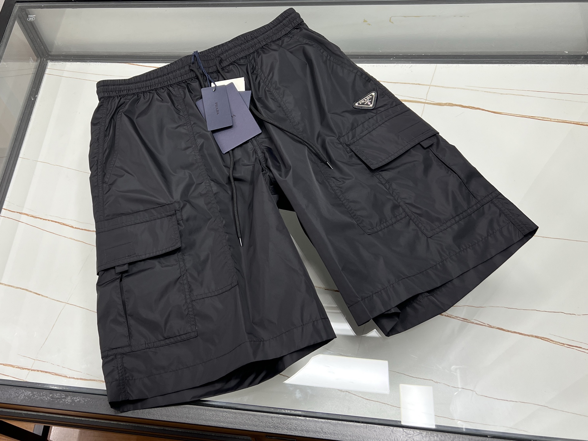 NO:830589,-26SS——Quick-drying casual and fashionable pocket pants, unlocking new summer trends. In the hot summer, a pair of quick-drying casual and fashionable pocket pants is essential!  It uses advanced quick-drying fabric, which can quickly absorb moisture and sweat, allowing you to bid farewell to the hot and sticky, stay dry and comfortable at all times, and enjoy outdoor activities. The mid-pants style is cleverly designed and the length is just right, which is not too restrictive and can show a neat figure. The multi-pocket design is super thoughtful, and small items such as mobile phones, keys, wallets, etc. can be easily stored, so you don’t need to carry cumbersome bags when going out. Fashionable style, simple and stylish, whether paired with a simple T  Whether it's a T-shirt or a personalized shirt, you can easily wear it, making you stand out in casual occasions and become the focus of the street. It is an indispensable and practical item in your summer wardrobe!  Available now in three colors S-XL, Prada-clothing, prada, wallets, shirts,19860909-26SS———速干休闲时尚口袋中裤,解锁夏日新潮流 夏日炎炎,一条速干休闲时尚口袋中裤必不可少！它采用先进速干面料,能快速吸湿排汗,让你告别闷热黏腻,时刻保持干爽舒适,尽情享受户外活动. 中裤版型设计巧妙,长度恰到好处,既不会过于束缚,又能展现利落身形.多口袋设计超贴心,手机、钥匙、钱包等小物件都能轻松收纳,出门无需再背繁琐包包. 时尚的款式,简约又不失格调,无论是搭配简约 T 恤还是个性衬衫,都能轻松驾驭,让你在休闲场合中脱颖而出,成为街头焦点,是夏日衣橱里不可或缺的实用单品！ 现货发售三色S-XL,普拉达-服装,prada,wallets,shirts,,Women's clothing