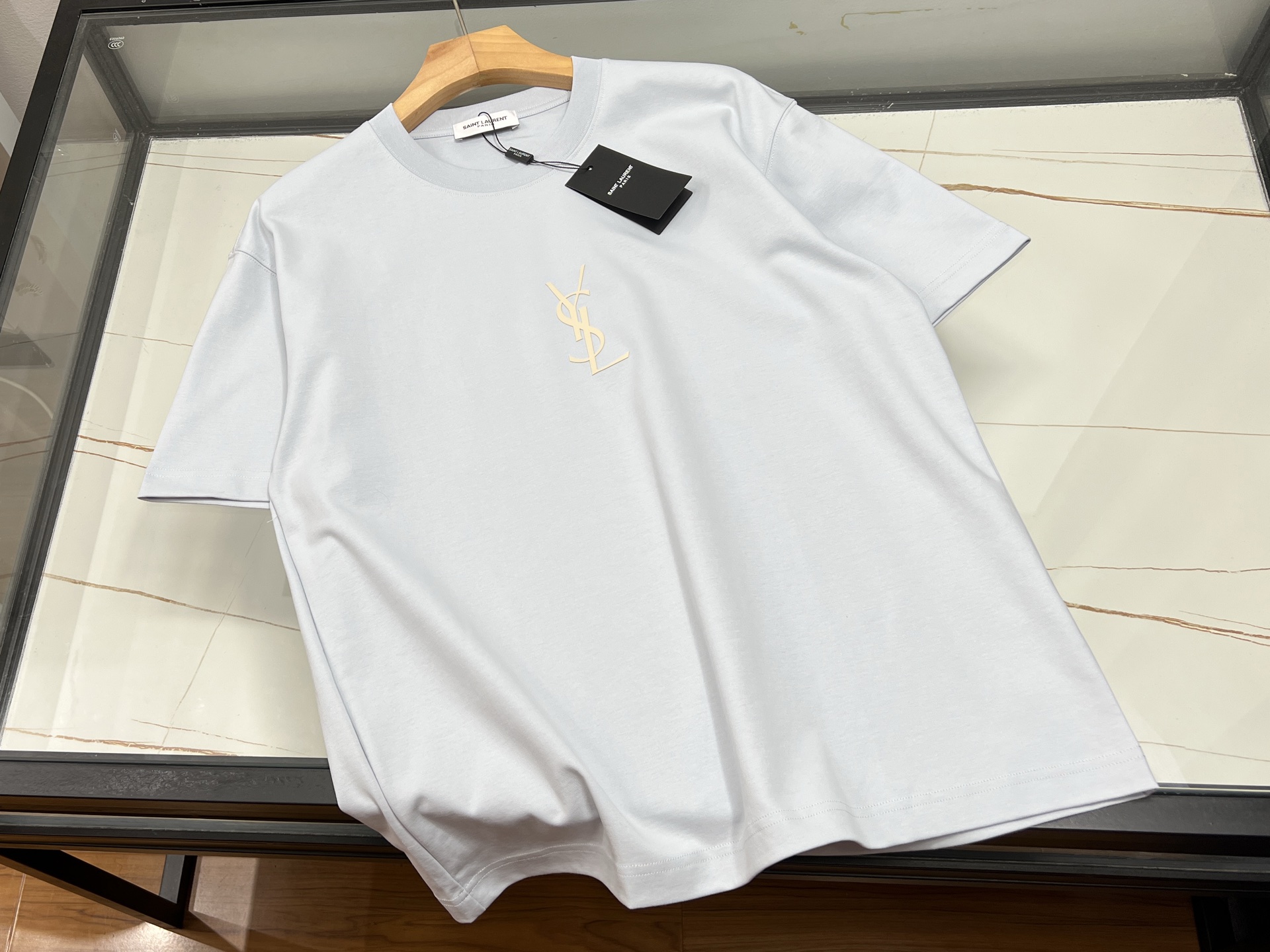 NO:860541,-26SS——Fashionable casual short sleeves with letter elements are a must-have eye-catching tool for fashionistas this summer!  Designers use bold creativity to cleverly combine letter printing with simple silhouettes, or embellish the chest with eye-catching three-dimensional letters, or cover the body with gradient graffiti letters, creating an uninhibited street feel. The oversize drop shoulder tailoring is paired with pure cotton fabrics, which is both lazy and casual, breathable and comfortable, whether it is paired with cool overalls.  You can easily style it with a cool style, or a sweet and spicy mix with layered suspender skirts. The jumping colorful letters on the classic black and white background, or the low-key letter arrangement in the Morandi color series, not only meet the low-key needs of daily commuting, but also can instantly become the focus at weekend parties. One piece unlocks N possible outfits, turning a basic style into a fashion statement in an instant!  Ready for sale blue XS-S-M-L, Saint Laurent-clothing, saint laurent, versace, skirts, T-shirt,19860909-26SS———字母元素加持的时尚休闲短袖,是今夏潮人必备的吸睛利器！设计师以大胆创意将字母印花与简约版型巧妙融合,或以醒目立体字母点缀胸前,或用渐变涂鸦字母铺满衣身,打造出个性不羁的街头感.oversize落肩剪裁搭配纯棉面料,兼顾慵懒随性与透气舒适,无论是搭配工装裤的酷帅风,还是叠穿吊带裙的甜辣混搭,都能轻松驾驭.经典黑白底色上跳跃的彩色字母,或莫兰迪色系中的低调字母排列,既满足日常通勤的低调需求,又能在周末聚会中瞬间成为焦点,一件解锁N种穿搭可能,让基础款秒变潮流宣言！ 现货发售蓝色XS-S-M-L,圣罗兰-服装,saint laurent,versace,skirts,T-shirt,,Women's clothing