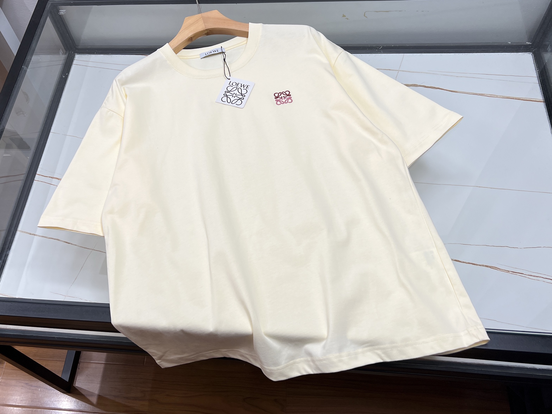 NO:892803,-26SS——Embroidered letter short sleeves, with its unique craftsmanship and fashionable design, have become the highlight of the summer wardrobe. This short sleeve is made of high-quality fabrics, soft and breathable, comfortable to wear, and suitable for various occasions. The exquisite embroidered letters not only show superb craftsmanship skills, but also give the clothes unique personality and charm. The letter patterns are diverse and can be selected according to personal preferences.  Whether it is a simple style of capital letters or an artistic combination of patterns, it can highlight the unique taste of the wearer. The short sleeves are well-fitting and have smooth lines. Whether worn alone or as an inner layer, they can be easily worn and show a fashionable attitude. Whether it is for leisure travel or daily travel, short sleeves with embroidered letters are a fashion item that you cannot miss, making your summer outfit more colorful.  Ready for sale beige XS-S-M-L, Loewe-clothing, loewe, T-shirt,19860909-26SS———刺绣字母短袖,以其独特的工艺与时尚设计,成为夏日衣橱中的亮点.这款短袖采用优质面料,柔软透气,穿着舒适,适合各种场合搭配.精致的刺绣字母,不仅展现了高超的手工艺技巧,更赋予了衣物独特的个性与魅力.字母图案多样,可根据个人喜好选择,无论是简约风格的大写字母,还是富有艺术感的图案组合,都能彰显穿着者的独特品味.短袖剪裁合身,线条流畅,无论是单穿还是作为内搭,都能轻松驾驭,展现时尚态度.无论是休闲出游,还是日常出行,刺绣字母短袖都是你不容错过的时尚单品,让你的夏日穿搭更加丰富多彩. 现货发售米黄XS-S-M-L,罗意威-服装,loewe,T-shirt,,Women's clothing