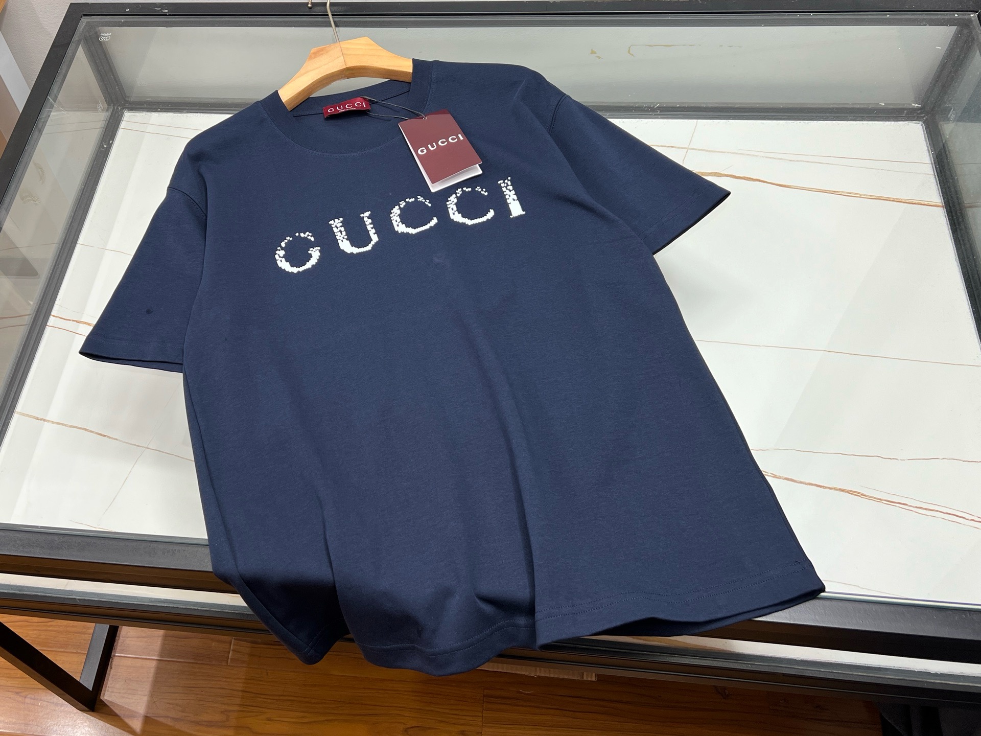NO:900211,-26SS————GU letter washed distressed short-sleeved T-shirt is a fashion item suitable for both men and women, which perfectly combines retro and modern trend elements. It is made of high-quality fabrics and treated with a special washing process to show a natural distressed effect, which not only enhances the texture of the clothes, but also gives each piece a unique appearance. The letter pattern on the body is simple yet individual. Through slight wear and tear, it shows the traces of time and highlights  The unique taste of the wearer. The short-sleeved design is suitable for spring and summer. It is cool and comfortable. The loose-fitting cut is suitable for both men and women regardless of body shape. When paired with jeans, casual pants or skirts, you can easily create a casual and natural street style. Whether it is daily travel, gatherings with friends or casual sports, this short-sleeved T-shirt is your ideal choice, allowing you to stand out from the crowd and show your extraordinary charm.  Ready for sale blue XS-S-M-L, Gucci-clothing, gucci, skirts, jeans, T-shirt, tees, t-shirt,19860909-26SS———GU字母水洗做旧短袖T恤,是男女皆宜的时尚单品,完美融合了复古与现代潮流元素.采用优质面料,经过特殊水洗工艺处理,呈现出自然做旧效果,不仅增强了衣物的质感,还让每一件都拥有独一无二的外观.衣身上的字母图案,简约而不失个性,通过轻微磨损处理,更显岁月痕迹,彰显穿着者的独特品味.短袖设计,适合春夏季节穿着,既凉爽又舒适.宽松的版型剪裁,不挑身材,无论男女都能轻松驾驭,搭配牛仔裤、休闲裤或是半身裙,都能轻松打造出随性自然的街头风格.无论是日常出行、朋友聚会还是休闲运动,这款短袖T恤都是你的理想选择,让你在人群中脱颖而出,展现不凡魅力. 现货发售蓝色XS-S-M-L,古驰-服装,gucci,skirts,jeans,T-shirt,tees，t-shirt,,Women's clothing