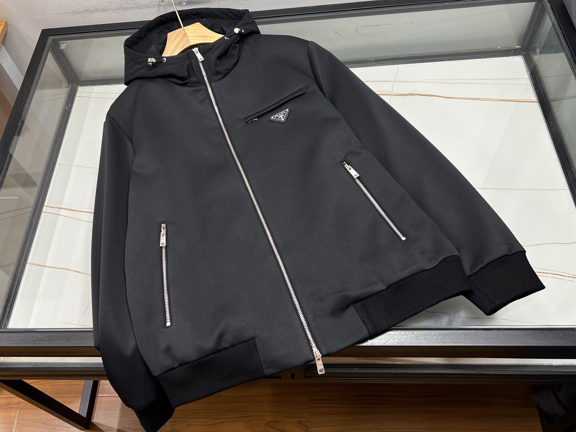 NO:951798,-26SS——Space cotton fashion jacket  Selected high-elastic space cotton fabric, air sandwich structure is light and crisp, with built-in three-dimensional shaping effect, it is not easy to collapse or wrinkle after long-term wear, taking into account comfort and fit. It is loose and simple with dropped shoulders, the upper body is free and unrestricted, and adapts to a variety of body shapes. The neat stand-up collar is equipped with a full zipper design, which is easy to put on and take off, and the lines are clean and elegant. Overall  The design is simple and elegant, low-key yet trendy, and cleverly balances the casual texture. Practical pockets on both sides provide both beauty and storage functions. It is refreshing and smart to wear alone, or can be worn with long sleeves as a base layer, making it easy to adapt to daily commuting, outdoor travel and other scenes. It is simple and versatile, taking into account both appearance and practicality, creating a refreshing and neat daily look for men.  Ready for sale black M-XXXL, Prada-clothing, prada, jackets & coats,19860909-26SS———太空棉时尚外套 精选高弹太空棉面料,空气夹层结构轻盈挺括,自带立体塑形效果,久穿不易塌陷、不起褶皱,兼顾舒适与版型.宽松简约落肩剪裁,上身自在无拘束,适配多种身形.利落立领搭配全开拉链设计,穿脱方便,线条干净大气.整体设计简约大气,低调不失潮流感,巧妙平衡休闲质感.两侧实用插袋,兼具美观与收纳功能.单穿清爽干练,亦可内搭长袖打底,轻松适配日常通勤、户外出行等场景.简约百搭,兼顾颜值与实穿性,打造清爽利落的男士日常造型. 现货发售黑色M-XXXL,普拉达-服装,prada,jackets & coats,,Women's clothing
