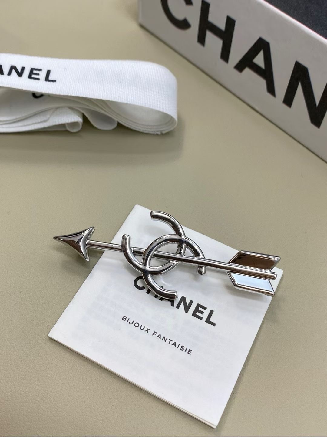 NO:765428,88170 [New product sharing] Ch@nel 26 Cupid’s Arrow brooch, gold and silver color, fashionable and high-end brooch combination. The arrow is neat and double C is entangled, combining French elegance and Cupid’s heartbeat into one brooch.  There are two colors of gold and silver to choose from, no unnecessary decoration, and clean lines. It has the heroic spirit of a retro knight and the unique sophistication of Chanel. It is a careful design that can make the outfit 'alive' instantly.,, chanel, brooch, breastpin, Cartier high-end jewelry1986090988170【新品分享】 Ch@nel 26丘比特之箭胸针 金银配色 时髦又高级的别针搭配 箭头利落,双C缠绕,把法式优雅与丘比特的心动感揉进一枚胸针里. 金银双色可选没有多余装饰,线条干净利落,既有复古骑士的英气,又有香奈儿独有的精致,是能让穿搭瞬间“活”起来的小心机.,,chanel,brooch，breastpin,卡迪亚高端饰品,Jewelry