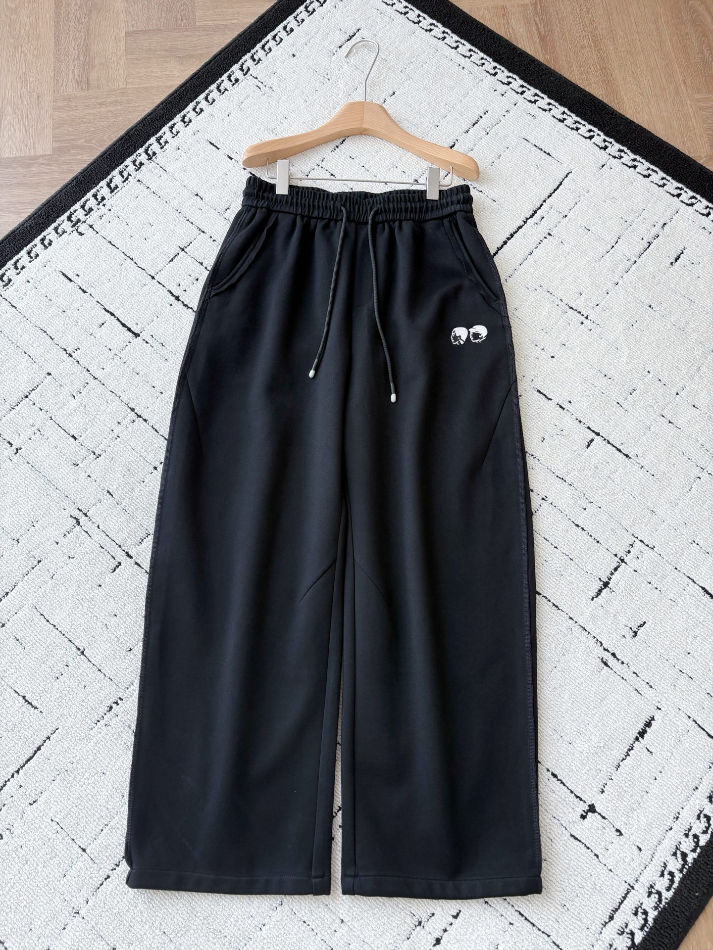 NO:598834,V workwear villain high weight knitted cotton wide-leg pants. Cool style, texture is king - LV workwear villain high weight wide-leg pants!  When the crisp texture of high-weight fabric meets V's iconic workwear embroidery, these black wide-leg pants become a perfect fusion of street and high-end fashion. The elastic waistband is matched with a textured drawstring, which can be adjusted casually to show a trendy attitude; the three-dimensional cut of the wide-leg version modifies the shape of the legs and is full of a lazy tone.  The embroidery of the workwear figure on the front is exquisite and eye-catching, and the three-dimensional pockets on the back are hidden with clever details. Every design interprets the 'high-end casual' dressing philosophy. Whether it is paired with a trendy sweater to create a street style, or it is combined with a simple shirt to create a yuppie feel, it can hold the audience with its super texture. Men's style, black, XS-L size; 1-3CM error in flat measurement  S code: Waist 79 crotch position 35 Leg circumference 70 pants length 106 M code: Waist 82 crotch position 36 Leg circumference 72 pants length 107 L size: Waist circumference 86 crotch position 37 Leg circumference 74 pants length 108 PS: The waistband is elastic and can be stretched to about 6CM per size. Size recommendation: Choose XS size if you are under 135 catties; choose S size if you are 135-150 catties;  If you are 150-170 pounds, choose size M; if you are 170-185 pounds, choose size L.,,louis vuitton,hoodie,sweatshirts,shirts,alexander wang19860909V工装小人高克重针织棉阔腿裤 潮酷型格,质感为王——LV工装小人高克重阔腿裤！ 当高克重面料的挺括质感邂逅V标志性工装小人刺绣,这条黑色阔腿裤便成了街头与高端时尚的完美融合体.松紧腰头搭配质感抽绳,随性调节间尽显潮人态度；立体剪裁的阔腿版型,修饰腿型的同时又满是慵懒腔调. 正面工装小人刺绣精致吸睛,背面立体口袋暗藏细节巧思,每一处设计都在诠释“高级休闲”的穿搭哲学.无论是搭配潮牌卫衣打造街头风,还是与简约衬衫碰撞雅痞感,它都能以超强质感hold住全场. 男款,黑色,XS-L码； 平铺测量1-3CM误差 XS码:腰围76裆位34腿围68裤长105 S码:腰围79裆位35腿围70裤长106 M码:腰围82裆位36腿围72裤长107 L码:腰围86裆位37腿围74裤长108 PS:裤腰有弹性,每码可拉伸至6CM左右 尺码推荐 135斤以下选择XS码；135-150斤选择S码； 150-170斤选择M码；170-185斤选择L码.,,louis vuitton,hoodie,sweatshirts,shirts,alexander wang,Men's clothing