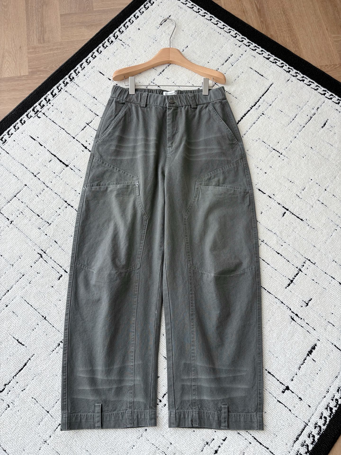 NO:598831,MM6 camouflage work pocket pants are a pioneering fusion of deconstruction and workwear aesthetics. When Maison Mar**la’s deconstruction gene meets the hard-core accent of workwear style, these camouflage work pocket pants use a pioneering design to reshape the artistic sense of daily wear.  The gray-tone camouflage texture is low-key and full of details, and the wide silhouette is compatible with multiple styles. Whether it is paired with an avant-garde top to create a show-level look, or it is combined with a simple T-shirt to create a casual trend, it can accurately capture the 'high-end and effortless' dressing philosophy.  The details are fully brand-recognizable. The multi-dimensional work pockets combine practicality and design. The aged metal buckles and neat stitching outline the exquisite handwork. The skin-friendly texture of the cotton fabric is suitable for all-season wear. The humanized design of the elastic waistband allows comfort and style to coexist. From the street to the show, it breaks the style boundaries and uses Margiela-style deconstructed aesthetics, allowing you to show your unique pioneering taste in daily wear.  Men's model, military green, XS-L size; 1-3CM error in flat measurement  PS: The waistband is elastic, and each size can be stretched to about 6CM. Recommended sizes: Choose size XS if you are under 135 pounds; choose size S if you are 135-150 pounds; choose size M if you are 150-170 pounds; choose size L if you are 170-185 pounds., masion margiela, masion margiela, tees, t-shirt, alexander wang19860909MM6迷彩工装口袋裤解构主义与工装美学的先锋融合 当Maison Mar**la的解构基因邂逅工装风的硬核腔调,这条迷彩工装口袋裤以先锋设计重塑日常穿搭的艺术感. 灰调迷彩肌理低调又充满细节感,宽大的廓形剪裁兼容多元风格,无论是搭配先锋感上衣打造秀场级造型,还是与简约T恤碰撞出随性潮范,都能精准拿捏“高级不费力”的穿搭哲学. 细节处尽显品牌辨识度多维度工装口袋兼具实用性与设计感,做旧金属扣与利落缝线勾勒出手工感的精致,棉面料的亲肤质感适配全季穿着,松紧腰头的人性化设计让舒适与造型感并存. 从街头到秀场,它打破风格边界,以马吉拉式的解构美学,让你在日常穿搭中也能彰显独树一帜的先锋品味. 男款,军绿色,XS-L码； 平铺测量1-3CM误差 XS码:腰围76裆位34腿围68裤长106 S码:腰围79裆位35腿围70裤长107 M码:腰围82裆位36腿围72裤长108 L码:腰围85裆位37腿围74裤长109 PS:裤腰有弹性,每码可拉伸至6CM左右 尺码推荐 135斤以下选择XS码；135-150斤选择S码； 150-170斤选择M码；170-185斤选择L码.,,masion margiela,masion margiela,tees，t-shirt,alexander wang,Men's clothing