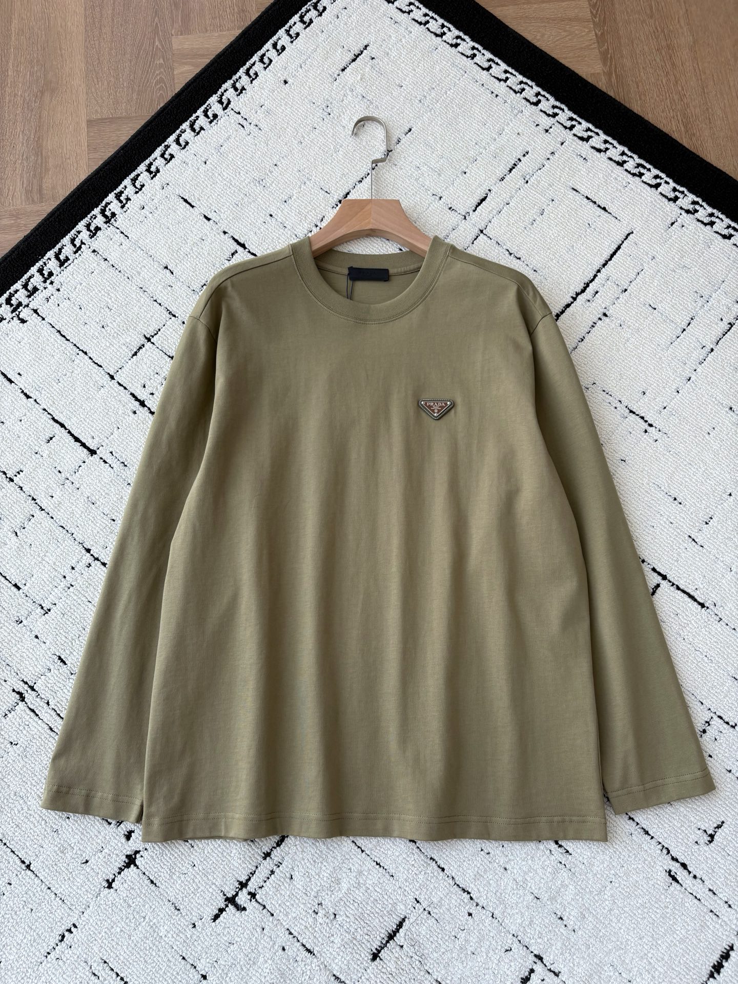 NO:571266,25 new autumn and winter styles~couple style!  PD avocado long-sleeved T is a must-have for autumn wear | Pra** avocado green long-sleeved T, with a lazy and high-end feel that can be worn with one click. It is made of skin-friendly fabric of 99 cotton + 1 polyester fiber, which is soft and breathable yet stiff and stylish, making it comfortable to wear close to the body; the iconic triangle logo on the chest, with the texture of leather and metal, low-key highlights the brand recognition, allowing the 'high-end sense' to be quietly revealed in the details.  The lazy oversize version is friendly to all body shapes, and couples can easily create a harmonious outfit when worn together. Whether worn alone to highlight a casual tone, or layered to create a layered style, this avocado green can make you stand out in autumn outfits and become the most eye-catching fashionable CP on the street!  Same style for men and women, avocado color; S-L size; 1-3CM error in flat measurement S size: shoulder width 48 bust 118 length 72 sleeve length 60 M size: shoulder width 49 bust 122 length 74 sleeve length 61 L size: shoulder width 50 bust 126 length 76 sleeve length 62 Girls choose S size; boys below 145 choose S size; 145-165 pounds choose M size;  165-185 pounds, choose L size.,,prada,versace,alexander wang1986090925秋冬新款~情侣款！PD牛油果长袖T 秋日穿搭CP必备｜Pra**牛油果绿长袖T,慵懒高级感一键拉满. 选用99棉+1聚酯纤维的亲肤面料,柔软透气却又挺括有型,贴身穿着舒适感拉满；胸前标志性的三角徽标,以皮革与金属的质感碰撞,低调彰显品牌辨识度,让“高级感”在细节处悄然流露. 慵懒的oversize版型对各种身形友好,情侣同穿轻松打造默契穿搭.不管是单穿凸显随性腔调,还是内搭叠出层次风格,这抹牛油果绿都能带你在秋日穿搭中脱颖而出,成为街头最吸睛的时髦CP！ 男女同款,牛油果色 ；S-L码； 平铺测量1-3CM误差 S码:肩宽48胸围118衣长72袖长60 M码:肩宽49胸围122衣长74袖长61 L码:肩宽50胸围126衣长76袖长62 女生选择S码； 男生 145以下选择S码；145-165斤选择M码； 165-185斤选择L码.,,prada,versace,alexander wang,Men's clothing