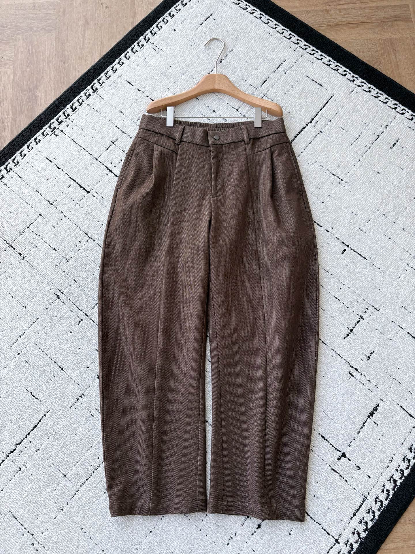 NO:656723,BV golden brown pure cotton custom woven gold thread herringbone pattern wide leg pants  The outer layer of these BV wide-leg pants is made of BV's signature custom-woven gold thread herringbone fabric. The golden brown background has fine silver glitter gold threads hidden in it. When walking, it shines like crushed sunlight. It feels like a soft and crisp cotton texture. It does not wrinkle or collapse. It is close to the skin and breathable as if you are not wearing pants. It is lined with satin of the same color, which makes it silky smooth to put on and take off without blocking the legs. It is not boring when worn with thick sweaters in autumn and winter.  The cut of high waist + wide legs + slightly bunched feet is the kind of style that 'whoever wears it will feel loose'. The waistband is elasticated and double-buttoned, which can hide the lower abdomen and adapt to different waist sizes; the trouser legs are loose but not draggy, and the wide hips and thick legs can be gently hidden. The trouser legs have neat straight ends, and sneakers are casual and noble. Pair them with high heels and you will become a cool lady instantly.  The hardware buttons and zippers have a matte metallic texture and are integrated with the golden brown fabric. The damping feeling when closing is visible to the naked eye; the side seams of the pockets are invisible zipper pockets, and the back pockets are patch pockets + buttons, which are safe for mobile phones and keys without damaging the minimalist lines of the pants; the seams of the technical trousers are double-locked, and the lining is so neatly hemmed that it looks like a work of art, and it will not pill and deform after being worn and washed many times. Men's style, brown, size XS-L.  Flat measurement error 1-3CM XS size: waist 80 crotch position 32 leg circumference 66 pants length 106 S size: waist 84 crotch position 33 leg circumference 68 pants length 106 M size: waist 88 crotch position 34 leg circumference 70 pants length 108 L size: waist 92 crotch position 35 leg circumference 72 pants length 108 PS: The waistband is elastic and can be stretched to about 6CM per size. Recommended size  If you are under 135 pounds, choose XS size; if you are 135-150 pounds, choose size S; if you are 150-170 pounds, choose size M; if you are 170-185 pounds, choose size L.,,bottega veneta,high heels,sweaters,alexander wang19860909BV金棕纯棉定织金线人字纹阔腿裤 这条BV阔腿裤外层是BV标志性的定织金线人字纹面料,金棕底色里藏着细密的银闪金线,走动时像揉碎的日光泛着绒光,摸上去是软而挺括的棉感肌理,不皱、不塌,贴肤透气到像没穿裤子；里衬同色系缎面,穿脱丝滑不卡腿,秋冬搭厚毛衣也不闷. 高腰+阔腿+微束脚的剪裁,是那种“谁穿谁有松弛感”的版型.腰头做了松紧+纽扣双设计,既能藏住小腹,又能适配不同腰围；裤管宽松却不拖沓,胯宽、腿粗都能被温柔藏住.裤脚是利落的直筒收尾,搭球鞋是休闲贵气,配高跟鞋秒变清冷大小姐. 五金纽扣、拉链都做了哑光金属质感,和金棕面料融为一体,拉合时的阻尼感是肉眼可见的精致；口袋侧缝是隐形拉链袋,后袋是贴袋+纽扣设计,放手机、钥匙都安全,还不会破坏裤身的极简线条；工艺裤缝是双道锁边,里衬包边工整到像艺术品,穿洗多次也不会起球变形. 男款,棕色,XS-L码. 平铺测量1-3CM误差 XS码:腰围80裆位32腿围66裤长106 S码:腰围84裆位33腿围68裤长106 M码:腰围88裆位34腿围70裤长108 L码:腰围92裆位35腿围72裤长108  PS:裤腰有弹性,每码可拉伸到6CM左右. 尺码推荐 135斤以下选择XS码；135-150斤选择S码； 150-170斤选择M码；170-185斤选择L码.,,bottega veneta,high heels,sweaters,alexander wang,Men's clothing