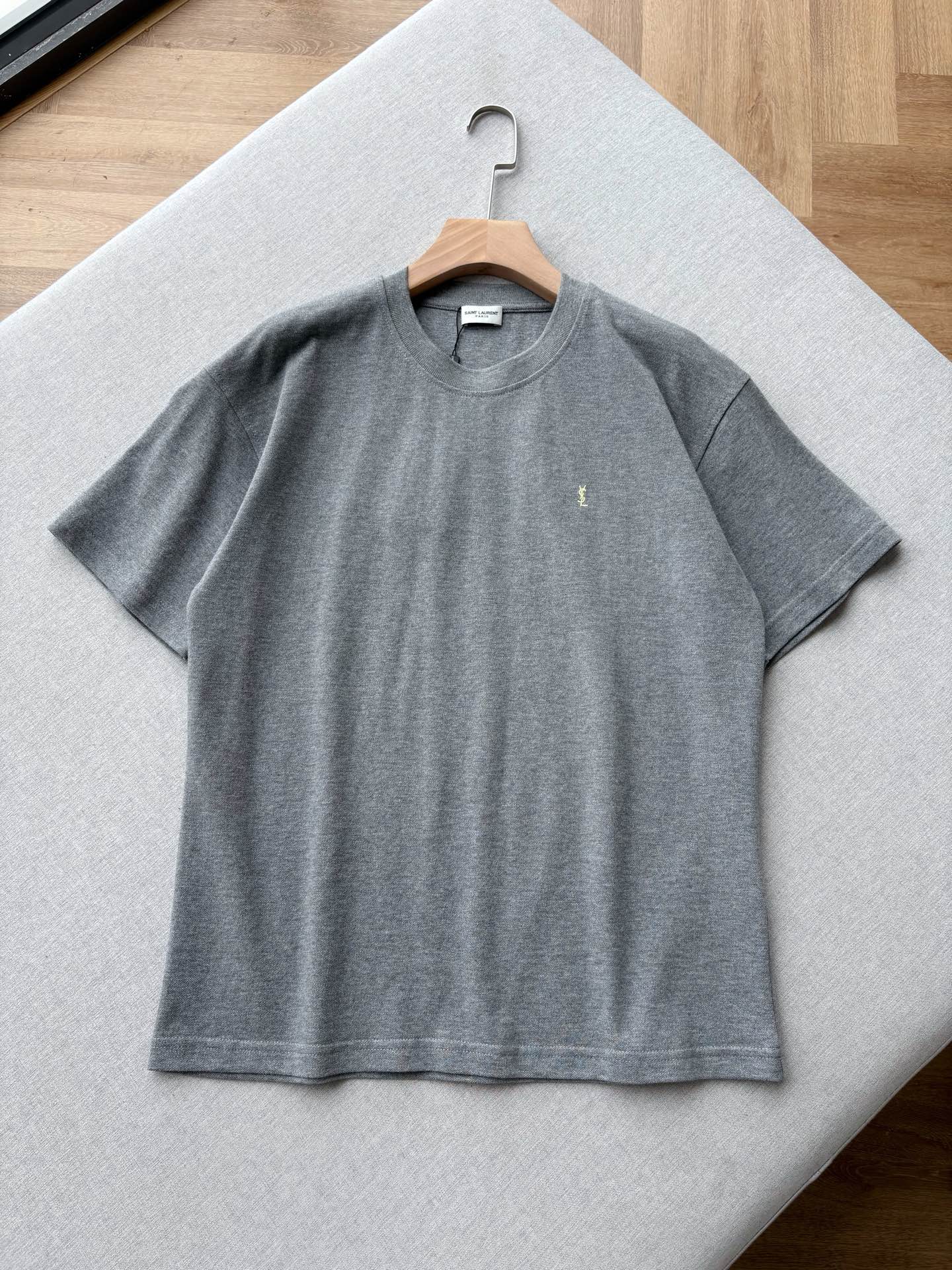NO:847309,YSL 26 spring and summer classic logo embroidered short-sleeved T-shirt. High-quality pique cotton fabric is selected to create the 2026 spring and summer classic basic T-shirt. The soft and high-grade gray embryo color is low-key and noble, with a matte high-grade texture. Say goodbye to the monotonous and cheap feeling of ordinary plain T-shirts.  The delicate and breathable pique cotton structure is breathable and wicks away sweat without stuffing the skin. It is refreshing and comfortable for the upper body in spring and summer. It is stiff and not easy to collapse and deform, and it can still maintain a neat silhouette after long-term wear. The YSL logo is exquisitely embroidered on the chest, which is low-key and luxurious without being exaggerated. It accurately interprets the French minimalist high-end style.  The loose, dropped-shoulder cut accommodates all body shapes, is not tight or bloated, and gives a casual and lazy atmosphere. The versatile gray is suitable for skin tones, and can be easily controlled by yellow or white skin. It comes with a cold-toned whitening filter. Minimalist and no unnecessary design, can be worn alone or layered, suitable for casual, commuting, and light luxury styles. It is an indispensable and versatile high-end basic model for wardrobes. Same style for men and women, gray, S-XL size; 1-3CM error in tile measurement  S code: Shoulder width 53 Bust 106 Clothes length 69 Sleeves 20 M code: Shoulder width 54 Bust 110 Clothes length 70.5 Sleeves 21 L code: Shoulder width 56 Bust 114 Clothes length 72 Sleeves 22  If you weigh 150-165 pounds, choose size L; if you weigh 165-180 pounds, choose size XL.,,saint laurent,T-shirt,tees,t-shirt,19860909YSL 26春夏经典Logo绣花短袖T恤 甄选高级质感珠地棉面料打造2026春夏经典基础T恤,柔和高级灰胚色低调显贵,自带哑光高级肌理感,告别普通平纹T恤的单调廉价感. 细腻透气的珠地棉结构,透气排汗不闷肤,春夏上身清爽舒适,挺括不易软塌变形,久穿依旧保持利落版型.胸口精致简约刺绣YSL标识,低调轻奢不浮夸,精准诠释法式极简高级格调. 宽松落肩剪裁包容各种身形,不紧绷不臃肿,随性慵懒氛围感拉满.百搭灰色巨衬肤色,黄皮、白皮轻松驾驭,自带冷调显白滤镜.极简无多余设计,可单穿可内搭,适配休闲、通勤、轻奢多种风格,是衣橱不可或缺的万年百搭高级基础款. 男女同款,灰色,S-XL码； 平铺测量1-3CM误差 S码:肩宽53胸围106衣长69袖子20 M码:肩宽54胸围110衣长70.5袖子21 L码:肩宽56胸围114衣长72袖子22 XL码:肩宽58胸围118衣长73.5袖子23 女生选择S码； 男生 135斤以下选择S码；135-150斤选择M码； 150-165斤选择L码；165-180斤选择XL码.,,saint laurent,T-shirt,tees，t-shirt,,Men's clothing