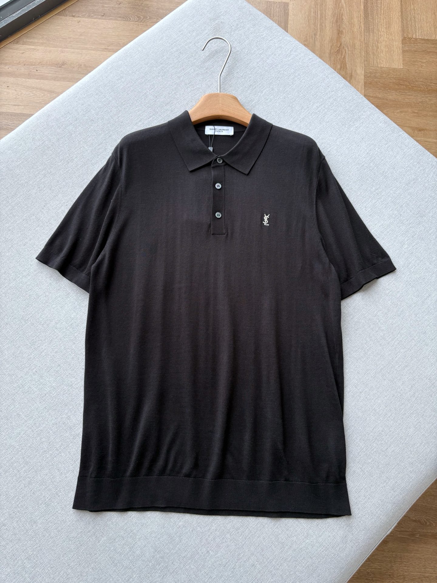 NO:847306,YSL 26 spring and summer black knitted POLO shirt brings Italian elegance to everyday effortless high-end. It is made of high-count worsted knitted fabric, which is delicate and skin-friendly, with a soft drape. The upper body is light and breathable, and it does not feel stuffy when worn in spring and summer. The classic black tone is versatile, and the off-white YSL embroidered logo on the chest is low-key and eye-catching. It is matched with resin buttons of the same color. The brand's iconic neat aesthetics is hidden in the details.  Neat and slightly loose version, not picky about body shape, modify the shoulder line and body shape, wear it alone to bring a relaxed aura, and can be easily controlled when layered with a suit. Men's style, black, XS-L size; 1-3CM error in flat measurement XS size: shoulder width 45, bust 100, dress length 69, sleeve length 25  M code: Shoulder width 47 Bust 108 Clothing length 73 Sleeve length 26 L code: Shoulder width 48 Bust 112 Clothes length 75 Sleeve length 26.5 Girls choose XS code; Boys below 130 pounds choose XS code; 130-145 pounds choose S code; 145-160 pounds choose M code; 160-175 pounds choose L code;,, saint laurent, business suit,19860909YSL 26春夏黑色针织POLO衫 把意式优雅,穿成日常里的不费力高级感. 采用高支精纺针织面料打造,触感细腻亲肤,自带柔和垂坠感,上身轻盈透气,春夏穿着也毫无闷热感.经典黑色调百搭不出错,胸口米白色YSL刺绣标识低调吸睛,搭配同色系树脂纽扣,细节里藏着品牌标志性的利落美学. 利落微宽松版型,不挑身材,修饰肩线与身形,单穿自带松弛气场,叠搭西装也能轻松驾驭. 男款,黑色,XS-L码； 平铺测量1-3CM误差 XS码:肩宽45胸围100衣长69袖长25 S码:肩宽46胸围104衣长71袖长25.5 M码:肩宽47胸围108衣长73袖长26 L码:肩宽48胸围112衣长75袖长26.5 女生选择XS码； 男生 130斤以下选择XS码；130-145斤选择S码； 145-160斤选择M码；160-175斤选择L码；,,saint laurent,business suit,,Men's clothing
