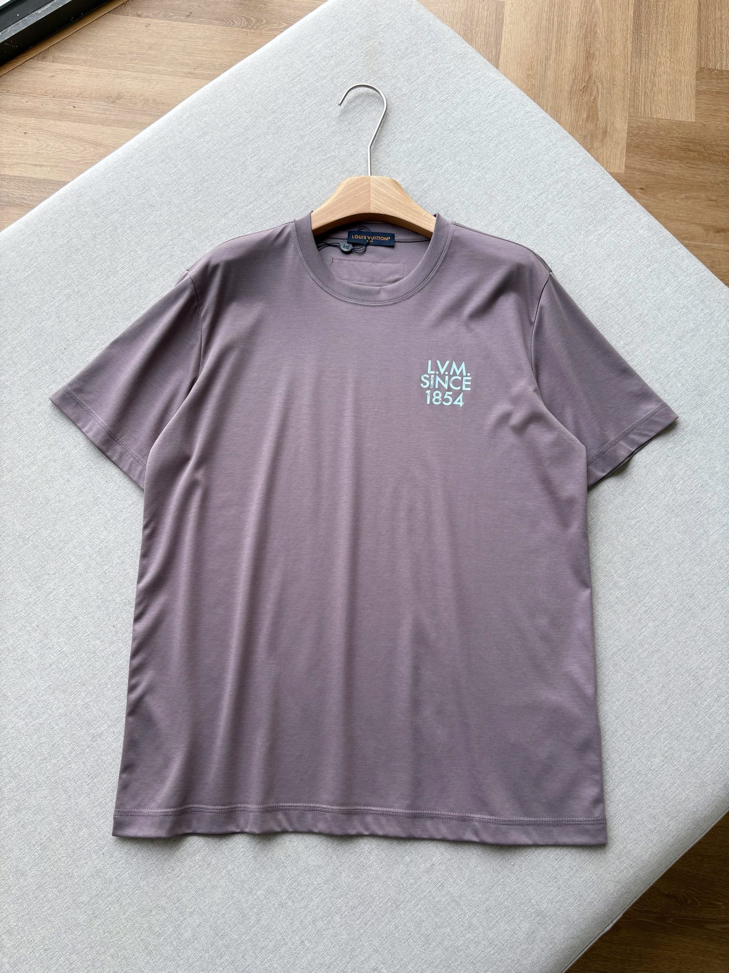 NO:847303,V 26 Spring and Summer Liquid Nitrogen Bean Paste Purple Letter Printed T-shirt is made of high-count long-staple cotton fabric, which has been treated with liquid nitrogen and liquid ammonia technology. It has a silky and soft touch, is anti-wrinkle and not easy to deform, and can maintain a crisp texture even after long-term washing. The bean paste purple low-saturated tone is gentle and high-end, and the 'LVM SINCE 4' letters are printed on the chest. The contrasting color design is low-key and eye-catching, and the V cloth label on the back is full of details.  The neat slightly loose tailoring is not picky and adapts to various body shapes. It brings a relaxed aura when worn alone or layered. The same style for men and women, bean paste purple, XS-XL size; 1-3CM error in flat measurement XS size: shoulder width 45, bust 102, dress length 67, sleeve length 22.5  M code: Shoulder width 47 Bust 110 Clothes length 71 Sleeve length 23.5 L code: Shoulder width 48 Bust 114 Clothes length 73 Sleeve length 24  150-165 pounds, choose size M; 165-180 pounds, choose size L; 180-jin, choose size XL.,,louis vuitton,tees,t-shirt,19860909V 26春夏液氮豆沙紫字母印花T恤 精选高支长绒棉面料,经过液氮液氨工艺处理,自带丝滑柔光触感,抗皱不易变形,久洗也能保持挺括质感.豆沙紫低饱和色调温柔又高级,胸口做旧感「LVM SINCE 4」字母印花,撞色设计低调吸睛,后背V布标细节拉满. 利落的微宽松剪裁,不挑身材,适配各种身形,单穿或叠搭都自带松弛气场. 男女同款,豆沙紫色,XS-XL码； 平铺测量1-3CM误差 XS码:肩宽45胸围102衣长67袖长22.5 S码:肩宽46胸围106衣长69袖长23 M码:肩宽47胸围110衣长71袖长23.5 L码:肩宽48胸围114衣长73袖长24 XL码:肩宽49胸围118衣长75袖长24.5 女生选择XS码； 男生 135斤以下选择XS码；135-150斤选择S码； 150-165斤选择M码；165-180斤选择L码； 180-斤选择XL码.,,louis vuitton,tees，t-shirt,,Men's clothing