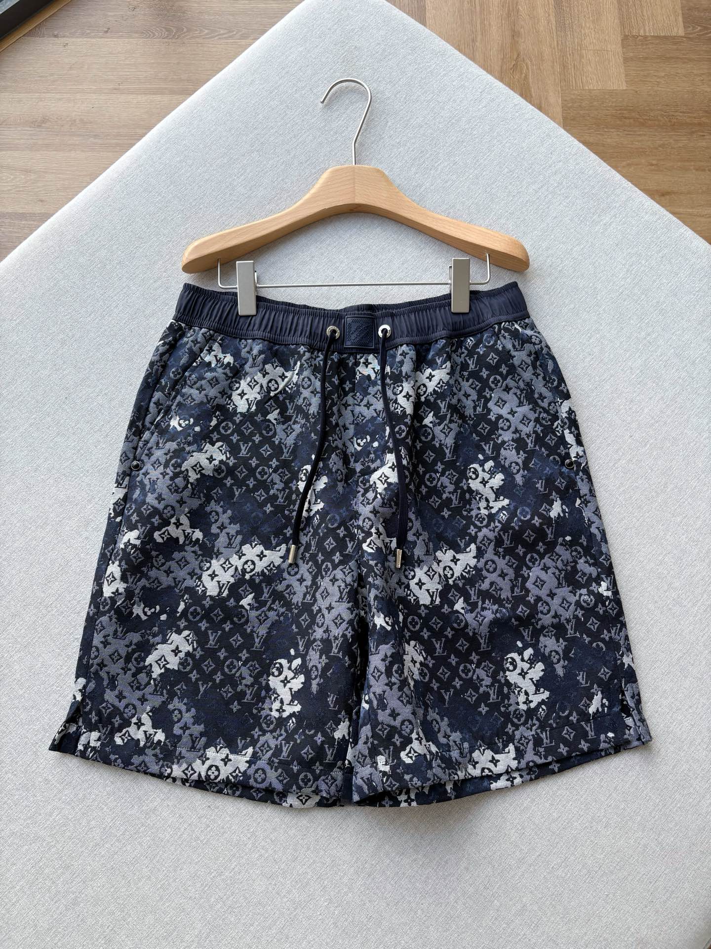 NO:911536,V ink-dyed presbyopic haute couture shorts | V’s 26th summer blockbuster, ink-dyed presbyopic haute couture casual shorts, reinterprets the classic Monogram elements with sfumato ink technology, and unlocks a low-key and luxurious trendy luxury style in the gradient layers of deep and light blue and black.  The high-definition jacquard fabric is selected, with a firm and textured texture, a delicate luster, and a straight and smooth upper body. The elastic waistband is paired with metal eyelets and branded webbing drawstrings. The metal rope head has exquisite engraving details, and the embossed leather tag on the waistband enhances recognition, demonstrating craftsmanship everywhere.  The loose five-quarter wide-leg cut accommodates various leg shapes. The side concealed button pockets combine practicality and design, and the back pockets are neatly routed. The retro ink smudge weakens the sense of presbyopia. It can be paired with solid color T-shirts and sweaters for daily use. It is easy to choose from light luxury casual to street cool styles. It is an iconic item in the wardrobe of high-end players. Men's style, dark blue, size XS-L; 1-3CM error when measuring flat.  XS code: Waist 76 crotch position 31 Leg circumference 64 trouser length 51 S code: Waist 80 crotch position 32 Leg circumference 66 trouser length 52 M code: Waist 84 crotch position 33 Leg circumference 68 trouser length 53 L code: Waist 88 crotch position 34 Leg circumference 70 trouser length 54 Recommended size The waistband is elastic and each size can be stretched to about 8CM  If you are under 135 pounds, choose XS size; if you are 135-150 pounds, choose size S; if you are 150-170 pounds, choose size M; if you are 170-185 pounds, choose size L.,,shorts,tees,t-shirt,19860909V墨染老花高定短裤｜ V家26夏季重磅力作,墨染老花高定休闲短裤,将经典Monogram元素以晕染水墨工艺重新演绎,在深浅蓝黑的渐变层次里,解锁低调奢华的潮奢格调. 甄选高定提花面料,肌理紧实有质感,自带细腻光泽,上身挺括垂顺.松紧腰头搭配金属气眼与品牌织带抽绳,金属绳头刻字细节精致,腰头压印皮牌强化辨识度,处处彰显匠心工艺. 宽松五分阔腿剪裁,包容各种腿型,侧边暗扣口袋兼顾实用性与设计感,后袋走线工整利落.复古水墨晕染弱化老花的张扬感,日常搭配纯色T恤、针织衫,轻松拿捏轻奢休闲、街头潮酷多种风格,是高阶玩家衣橱里的标志性单品. 男款,深蓝色,XS-L码； 平铺测量1-3CM误差 XS码:腰围76裆位31腿围64裤长51 S码:腰围80裆位32腿围66裤长52 M码:腰围84裆位33腿围68裤长53 L码:腰围88裆位34腿围70裤长54 尺码推荐裤腰有弹力,每码可拉伸至8CM左右 135以下选择XS码；135-150斤选择S码； 150-170斤选择M码；170-185斤选择L码.,,shorts,tees，t-shirt,,Men's clothing