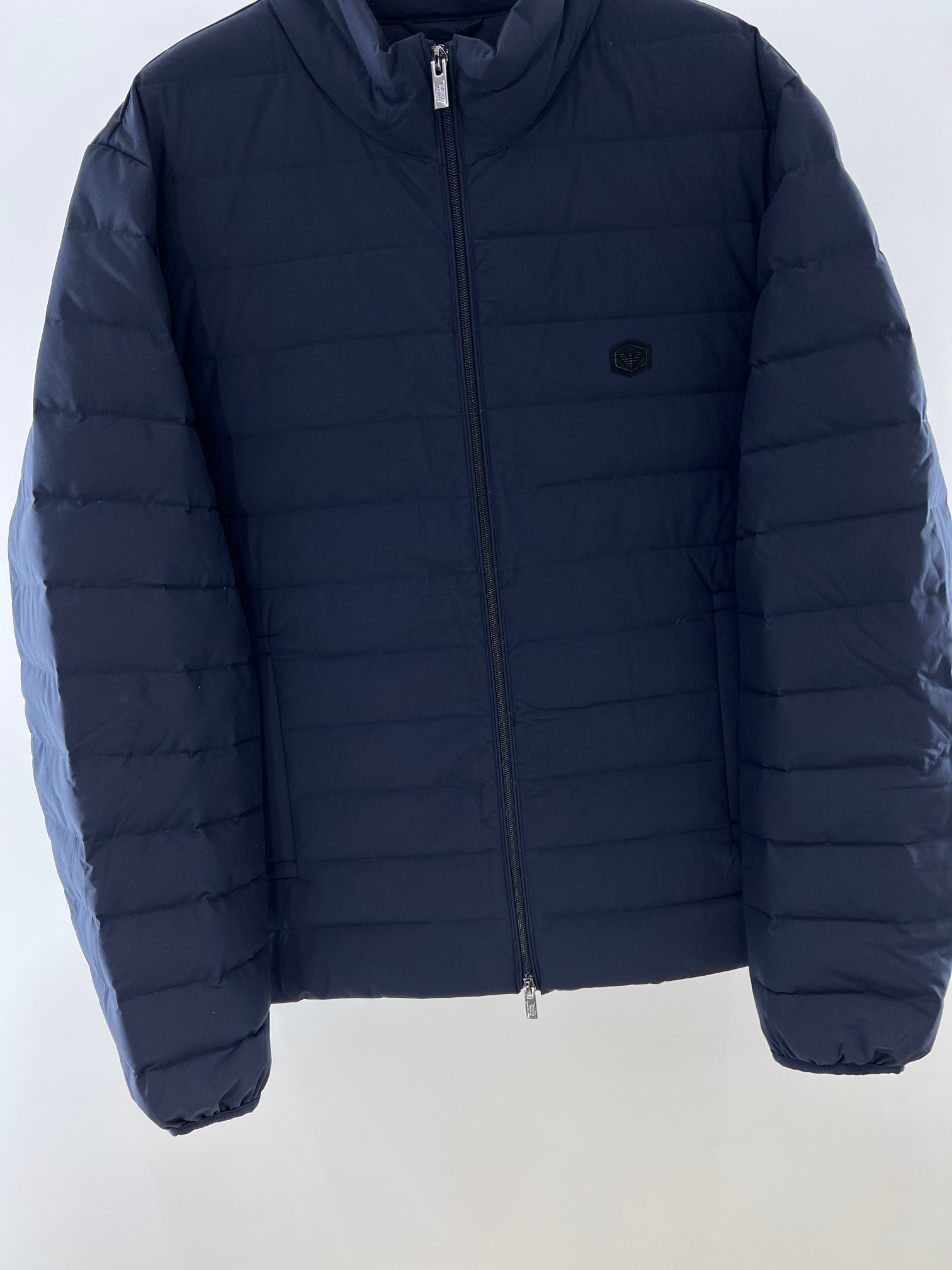 羽绒服-。 EMPORIO ARM**I 男士轻薄羽绒服 这款经典款，男士轻薄羽绒服以简约型格的焕新演绎