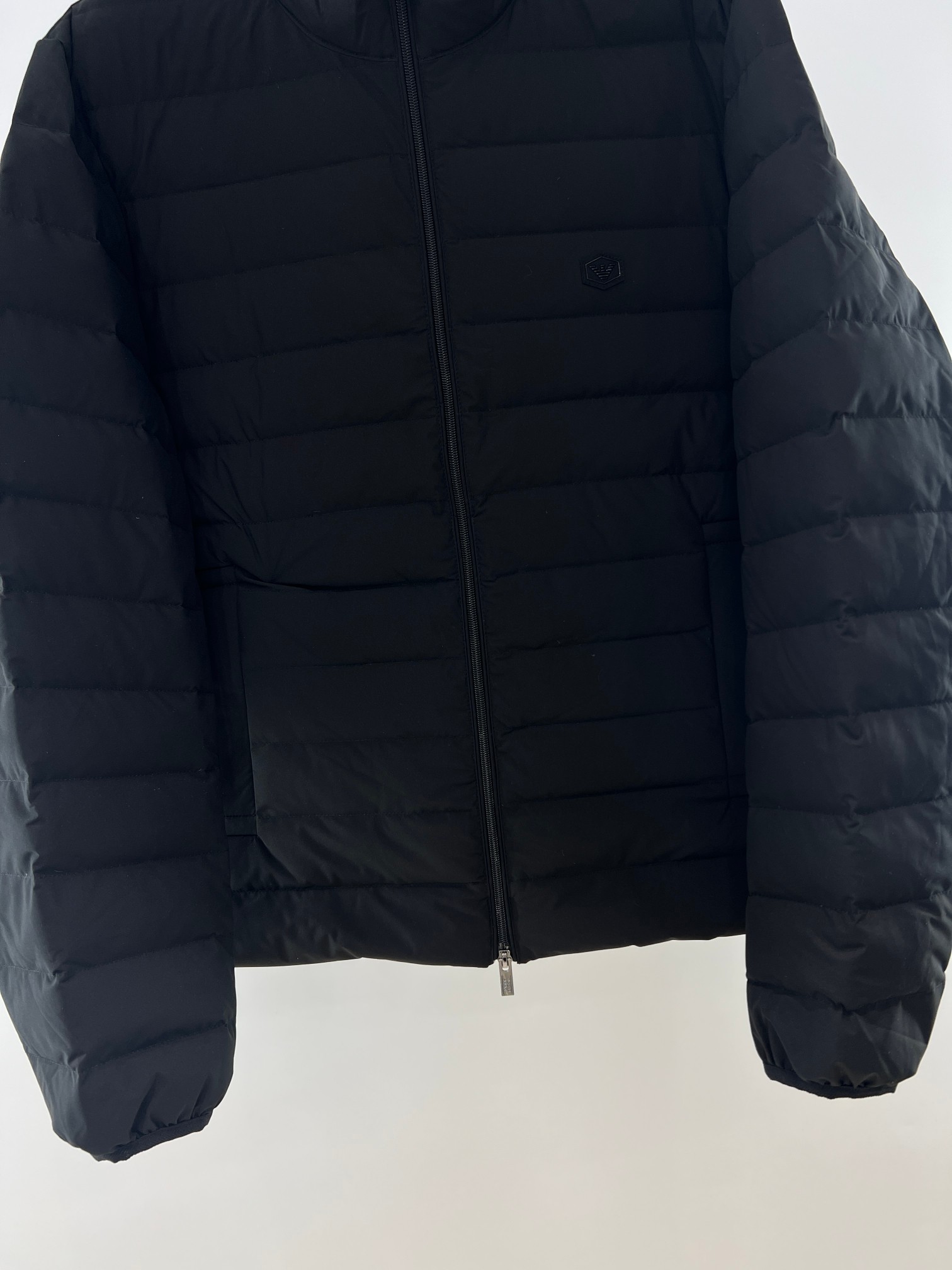 羽绒服-。 EMPORIO ARM**I 男士轻薄羽绒服 这款经典款，男士轻薄羽绒服以简约型格的焕新演绎