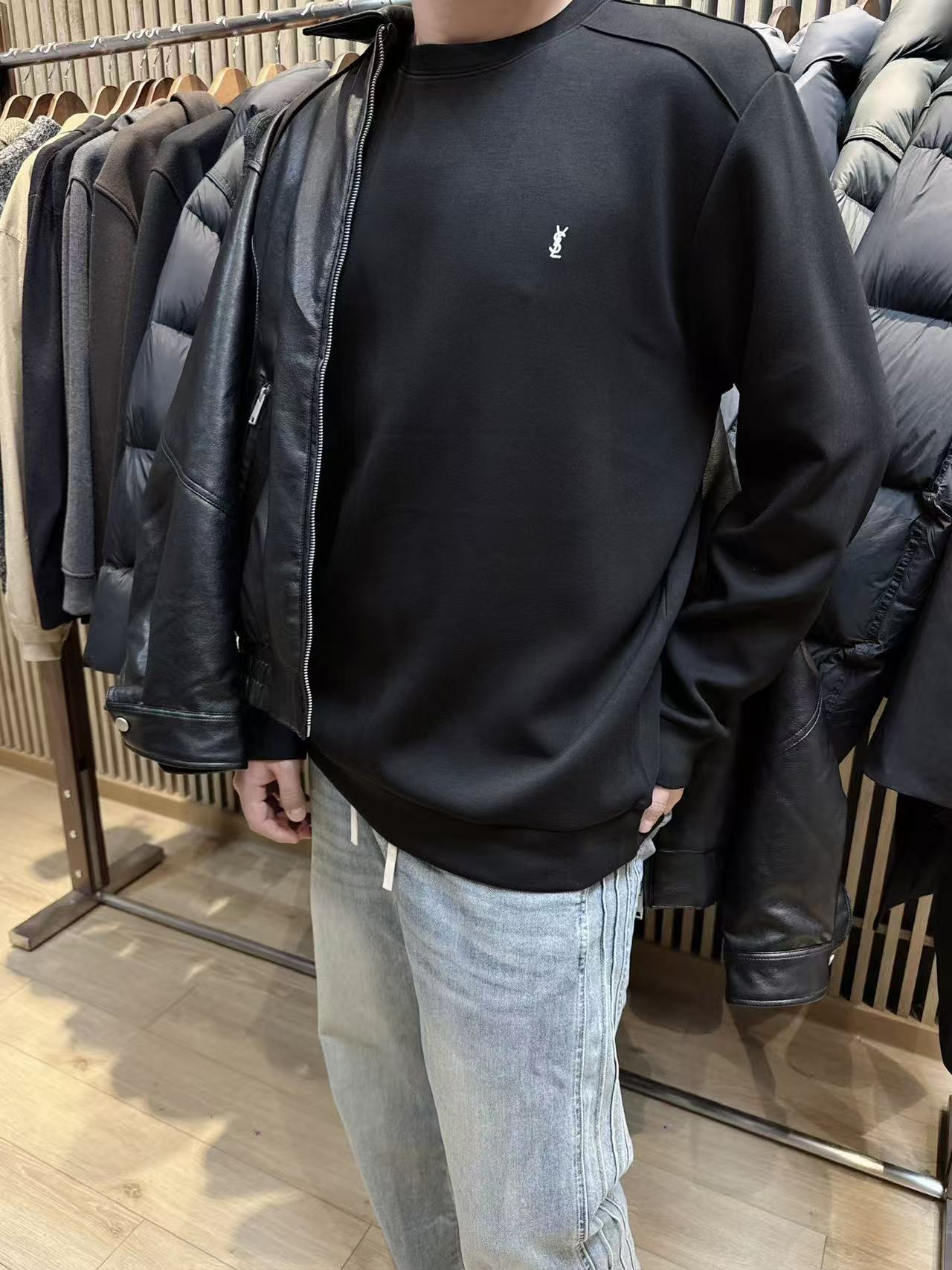 NO:684956,YSL three-color new model ~ milk silk smooth surface + skin-friendly warm sweatshirt with brushed interior. This brushed shoulder sweatshirt is made of milk silk outer fabric to create a delicate and smooth visual and tactile feel. The brushed interior craftsmanship gives the skin a cloud-like skin-friendly warmth experience. One garment can achieve the wearing enjoyment of 'slippery on the outside and warm on the inside', breaking the dilemma of choosing 'thick or thin' sweatshirts in autumn and winter.  The version abandons conventional tailoring and adopts a front shoulder patchwork design. The neat stitching outlines the three-dimensional shoulder line. The slightly dropped shoulder arc neutralizes the toughness of the front shoulder, retaining the sense of style without losing the casualness. On the simple solid color base of the garment, the YSL classic on the left chest  The classic embroidered logo is a low-key finishing touch, and the metallic embroidery threads form a delicate contrast with the smooth fabric, hiding the brand recognition in the details. The ribbed cuffs and hem are made of the same color high-elastic fabric, which fits closely but is not tight, and is not easy to deform after long-term wear, further strengthening the overall neat silhouette.  颜色黑色 白色 藏蓝 尺码S-XXL,,saint laurent,hoodie,sweatshirts,19860909YSL三色新款~表面牛奶丝光滑+内里拉毛亲肤保暖卫衣 这款拉毛滑肩卫衣以牛奶丝外层面料打造细腻光滑的视觉与触感,内里拉毛工艺则赋予肌肤云朵般的亲肤保暖体验,一衣实现“外滑内暖”的穿着享受,打破秋冬卫衣“厚重或单薄”的选择困境. 版型上摒弃常规剪裁,采用正肩拼线裁片设计,利落的缝线勾勒出立体肩线,滑肩的微落肩弧度中和了正肩的硬朗,既保留了型格感又不失休闲松弛度；衣身简约的纯色基底上,左胸处的YSL经典刺绣徽标低调点睛,金属质感的绣线与光滑面料形成精致对比,将品牌辨识度藏于细节.罗纹袖口与下摆采用同色高弹面料,紧密贴合却不紧绷,久穿不易变形,进一步强化了整体的利落廓形. 颜色黑色 白色 藏蓝 尺码S-XXL,,saint laurent,hoodie,sweatshirts,,Men's clothing