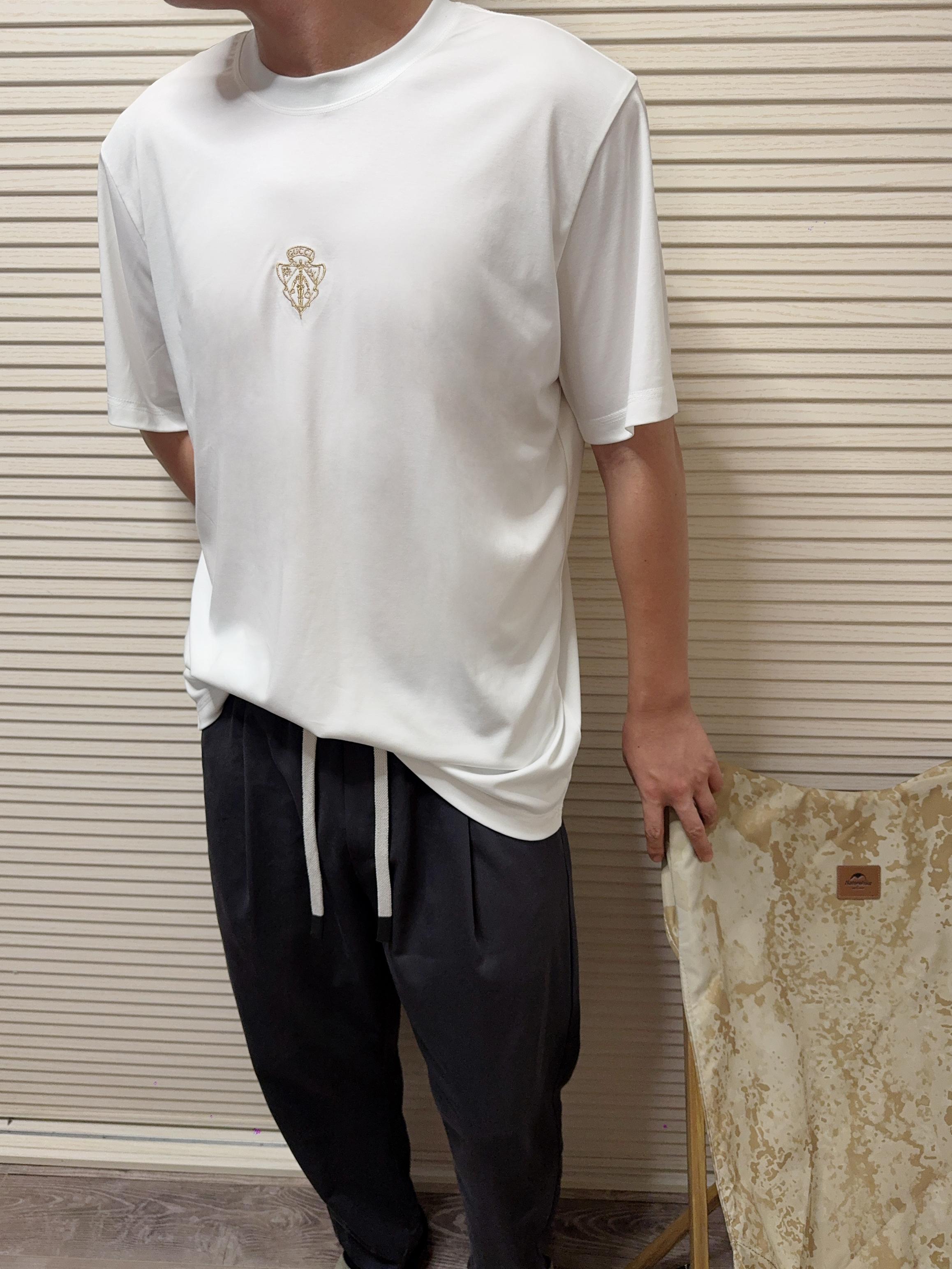 NO:937593,. GU retro knight's coat of arms gold thread embroidered round neck short-sleeved T-shirt GU knight's coat of arms gold thread embroidered white T-shirt, a low-key masterpiece of the luxury brand!  High-count long-staple cotton treated with liquid ammonia, silky, soft, breathable and anti-wrinkle; precision gold thread embroidery badge on the chest, glossy but not exaggerated, small logo restrained and high-end. Classic round neck + slightly loose dropped shoulders, suitable for both men and women regardless of body shape, suitable for commuting and leisure, pure white, versatile style, detailed routing and benchmarking counters, full of texture, the first choice for daily high-end base. Color white  Size XS-XL,,T-shirt,tees,t-shirt,19860909. GU复古骑士盾徽金线刺绣圆领短袖T恤 GU骑士盾徽金线刺绣白T,奢牌低调代表作！高支长绒棉液氨处理,丝滑软糯透气抗皱；胸口精密金线刺绣徽章,光泽显贵不浮夸,小logo内敛高级. 经典圆领+微宽松落肩,不挑身材男女通穿,通勤休闲两不误,纯白百搭万能款,细节走线对标专柜,质感拉满,日常刚需高级打底首选. 颜色白色 尺码XS-XL,,T-shirt,tees，t-shirt,,Men's clothing