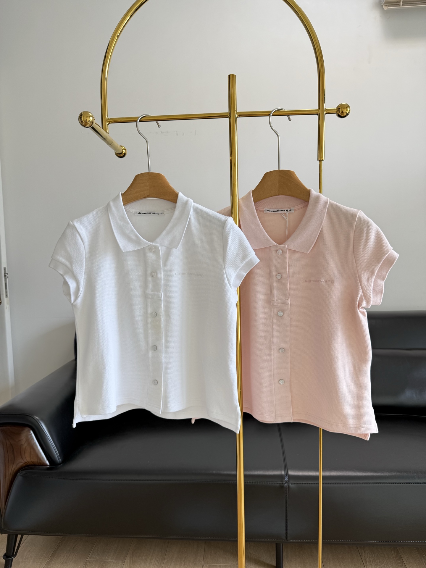 NO:326884,——alexanderwang Alexanderwang Lady's logo decorative short-sleeved polo cardigan T-shirt Polo cardigan is made of elastic bead flooring fabric, the collar, cuffs and hem are aged, blending street style and college feel, the short-sleeved design is combined with a crisp lapel, modifying the neck line. The front closure is designed with a button   snap button double closure design to create a casual and stylish layering effect, and the same color embroidery on the chest logo is low-key and recognizable, and it can easily wear high-end. Selected elastic bead flooring fabric, three-dimensional woven structure, has good clarity and breathability, and the touch is dry and not close. The neckline, cuffs and hem are treated with old washing water, rich details, the overall structure is straight but not hard, and it maintains comfort and presents a natural drooping feeling. Number sml Pink White 2 colors,,alexander wang,T-shirt,tees,t-shirt,alexander  wang19860909——alexanderwang亚历山大王女士徽标装饰短袖polo开衫t恤 Polo 开衫由弹力珠地棉面料制成,衣领、袖口和下摆经过做旧处理 融合街头风与学院感,短袖设计配合挺括翻领,修饰颈部线条.前襟采用纽扣 按扣双开合设计,打造随性有型的叠穿效果,胸前同色系刺绣 logo 低调又有辨识度,轻松穿出高级感 精选弹力珠地棉面料,立体织纹结构,具有良好的挺括性与透气性,触感干爽不贴身.领口、袖口及下摆采用做旧洗水处理,细节丰富,整体结构挺而不硬,保持舒适的同时呈现自然垂感 码数sml 粉色 白色2色,,alexander wang,T-shirt,tees，t-shirt,alexander wang,Women's clothing