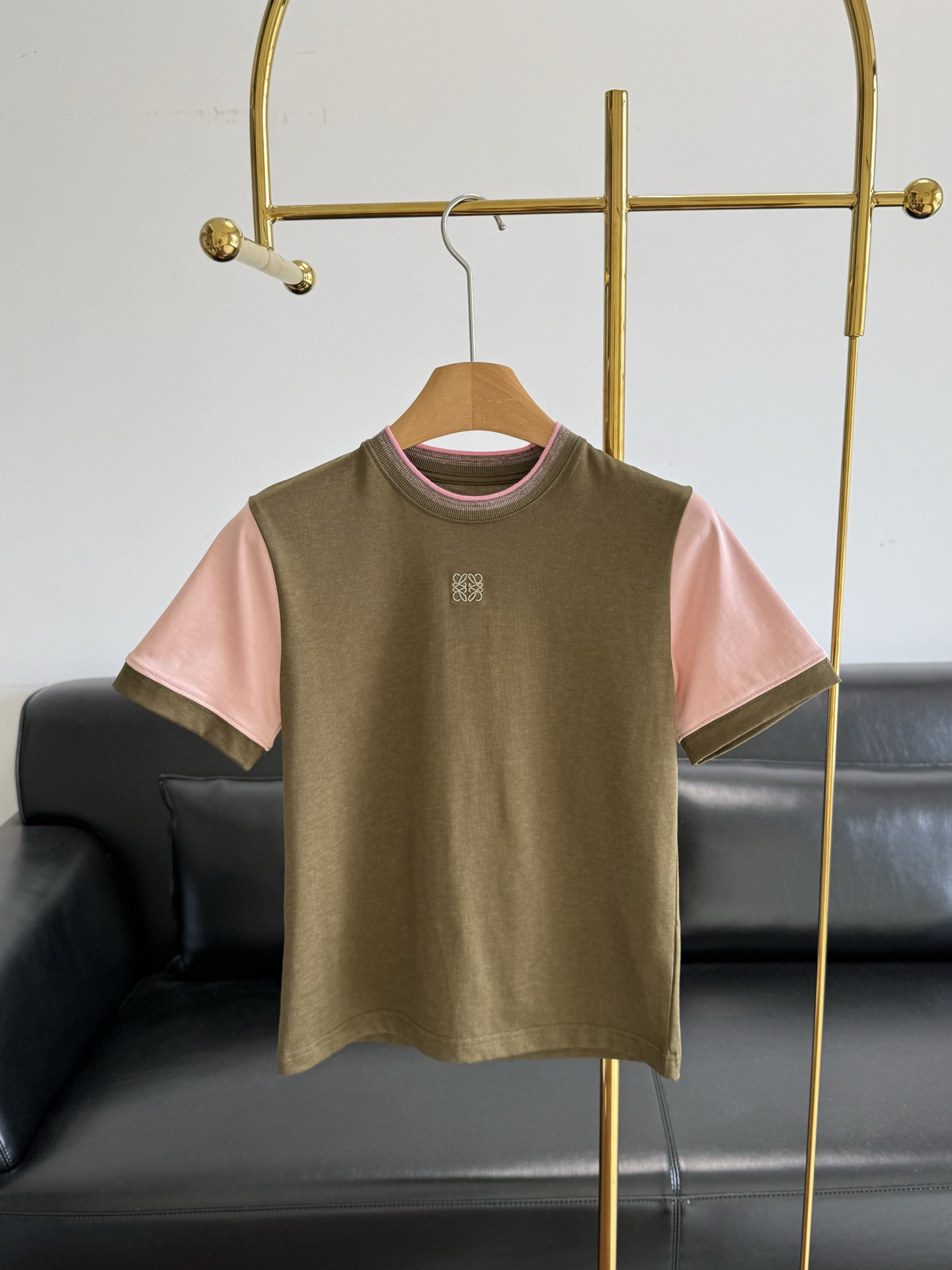 NO:790817,——Loewe 26Ss new spring and summer color block logo cotton short-sleeved round neck T-shirt  The main body is olive green, with contrasting pink and white short sleeves and neckline, creating a relaxed retro college feel. The exquisite Anagram embroidery on the chest is a low-key finishing touch. The high-count cotton fabric is soft and skin-friendly with slight elasticity. The slim fit fits the body shape without being tight. Whether it is worn with wide-leg jeans for a casual route or with an irregular skirt to create a light French style, it can become a versatile tool in the spring and summer wardrobe, allowing the sense of luxury to be naturally revealed in daily wear.  Size sml,,loewe,skirts,jeans,T-shirt,tees,t-shirt,19860909——Loewe 26Ss春夏新款 拼色logo棉质短袖圆领T恤 以橄榄绿为主体,撞色粉白短袖与领口,打造出松弛的复古学院感.胸前精致的同色系Anagram刺绣低调点睛,高支棉面料柔软亲肤且自带微弹,修身版型贴合身形却不紧绷,无论是搭配阔腿牛仔裤走休闲路线,还是配不规则半裙打造轻法式风格,都能成为春夏衣橱里的百搭利器,让高级感在日常穿搭中自然流露. 码数sml,,loewe,skirts,jeans,T-shirt,tees，t-shirt,,Women's clothing