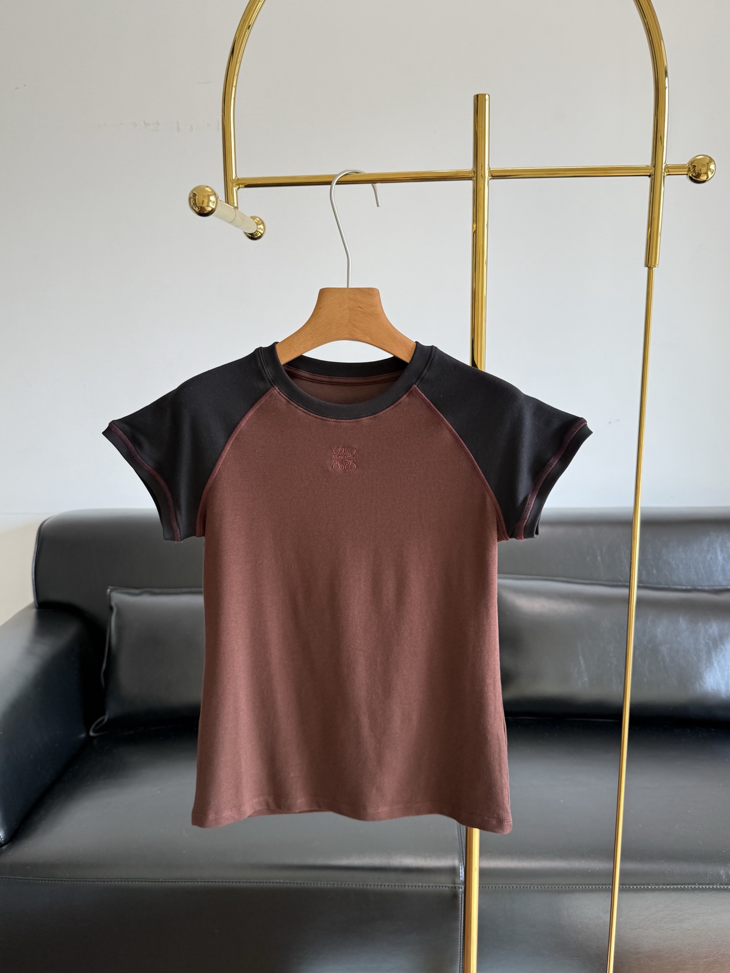 NO:792303,—Loewe's 26 early spring new style raglan short-sleeved contrasting colors, same style as Chen Duling!  The texture is divine!  Coffee color with a high-end feel!  With just the right balance between simplicity and texture, it is a matching tool that will never be missing in your wardrobe!  Selected and customized original twill cotton fabric, soft and delicate to the touch, high-end luxury texture that you can feel with your hands, soft but not collapsed, crisp and stylish, breathable and close to the skin, not stuffy and sweaty, and full of comfort. The workmanship is fine to every detail, the stitching of the Anagram logo embroidery on the chest is dense and flat, exquisite and three-dimensional, not obtrusive, low-key and high-level recognition, not easy to deform or pill after long-term wear  Classic brown and black contrasting raglan design, the color is high-end and attractive, the line from collar to cuffs is neat, the fit is slim and slightly elastic, just right to modify the body shape, slimming but not tight, the upper body is retro, lazy and noble. Sizes S, M, L,, loewe, T-shirt,19860909—Loewe同款26早春新款插肩撞色短袖 陈都灵同款！质感封神！自带高级感的咖色色系！把简约与质感平衡得恰到好处,是衣橱里永远缺不了的搭配利器！ 甄选定制原版斜纹全棉面料,触感软糯细腻,上手就能感受到的高奢质感,软而不塌、挺括有型,贴肤透气不闷汗,舒适度直接拉满 做工精细到每一处细节,胸前Anagram刺绣logo针脚密实平整,精致立体不突兀,低调暗藏高级辨识度,久穿不易变形、不起球 经典棕黑撞色插肩设计,配色高级耐看,领口到袖口走线工整,版型修身微弹,恰到好处修饰身形,显瘦不紧绷,上身复古慵懒又显贵 尺码S、M、L,,loewe,T-shirt,,Women's clothing
