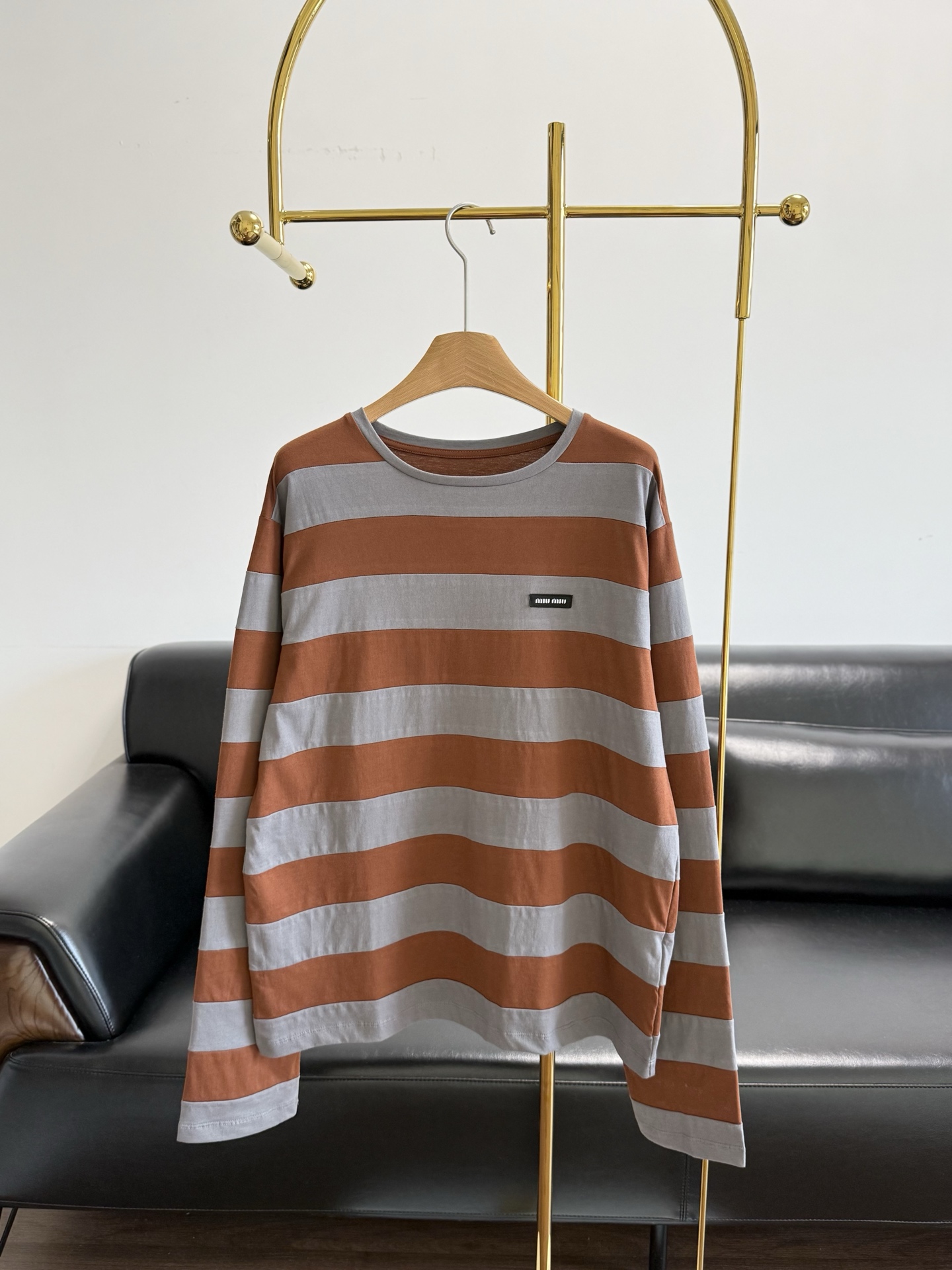 NO:830595,——Miumiu's striped long-sleeved t-shirt with the same letter logo is directly welded to the atmospheric ceiling. The contrasting stripes of caramel brown + matte gray are retro and white, and even yellow-skinned sisters can close their eyes!  The loose, off-shoulder version hides flesh and is lazy, made of pure cotton fabric!  The soft fufu fabric is skin-friendly and breathable. Wear it alone and look like a Korean heroine. Wear it layered with a vest and instantly transform into a preppy sweet girl. Size smL,,miumiu,19860909——Miumiu同款字母徽标条纹长袖t 直接焊死氛围感天花板 焦糖棕+雾灰的撞色条纹, 复古又显白,黄皮姐妹也能闭眼冲！ 宽松落肩版型藏肉又慵懒, 纯棉面料！软fufu的面料亲肤又透气,单穿是韩系女主,叠穿马甲秒变学院风甜妹. 码数smL,,miumiu,,Women's clothing