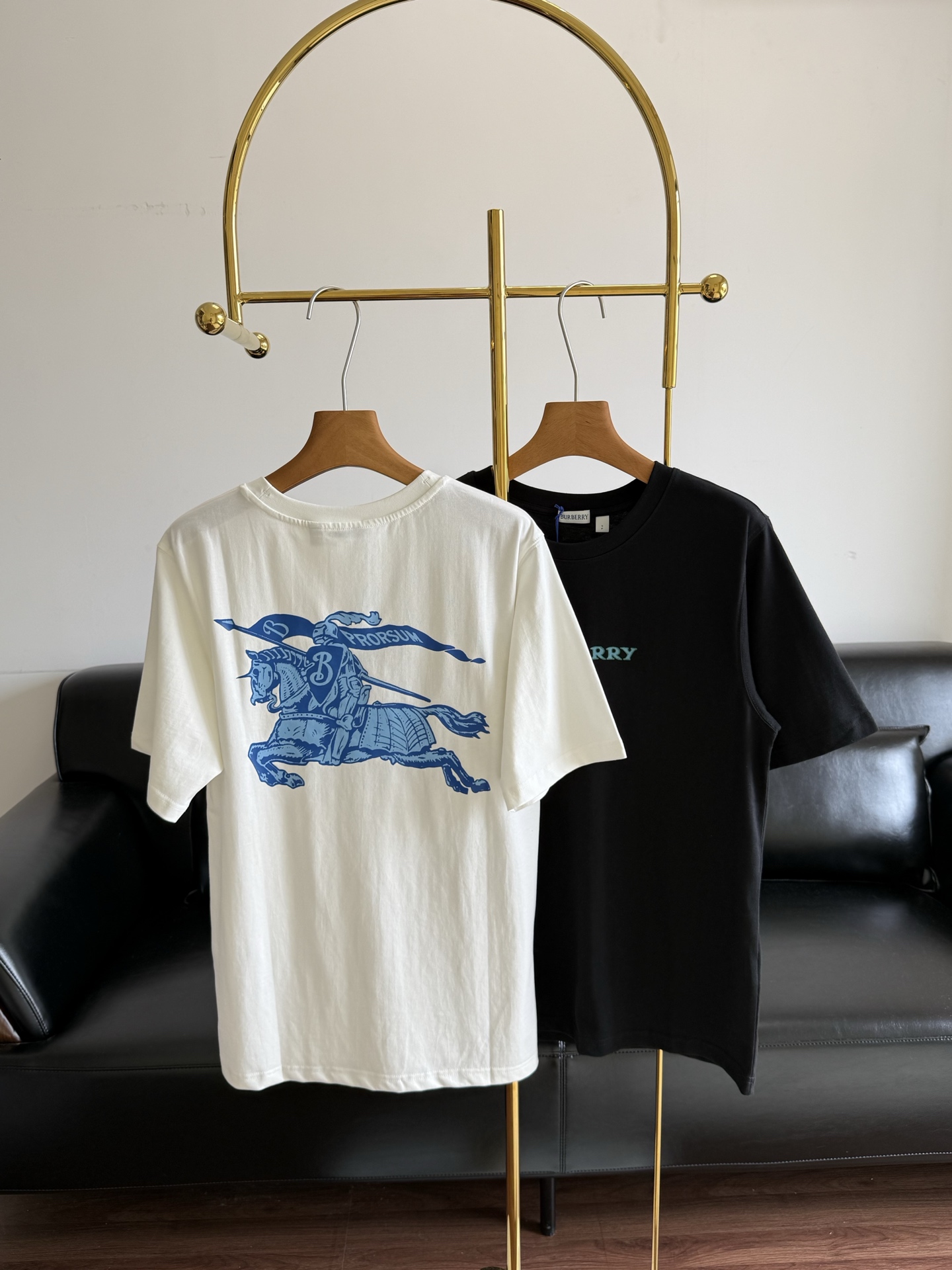 NO:855976,——BURBERR The same knight logo T-shirt, welded directly to the body and no need to take it off!  The fabric is soft and waxy, making it very comfortable to wear in summer. The imported high-count combed cotton has a soft and waxy but sinewy feel to the touch. It has an amazing drape feeling and does not stick to the upper body at all. It is very breathable in summer and does not stick to the body even if you sweat. It does not loosen or pill even after being washed ten or eight times, and the texture is straight forward!  The weight is just right at the golden point of 'straight but not heavy'. It won't show through the underwear, nor will it make you feel stuffy. It's suitable for wearing alone or as an inner layer, and can be worn all year round!  The BBR letter logo on the front is a customized two-color contrasting print with clean edges. The color is exactly the same as Zp's lake blue/navy blue. It has a slight three-dimensional feel to the touch and will not peel off or crack at all!  The knight logo on the back is the highlight!  The word Prorsum, the texture of the knight's armor, and every line of the war horse are all clearly restored. The two-color gradient printing process directly adds a sense of layering. From a distance, it looks like a low-key solid-color T-shirt, but up close, it is full of details. It is low-key and has a sense of high-end, and it does not conflict with the style at all!  Size s-xl white black, burberry, tees, t-shirt, gold,19860909——BURBERR 同款骑士标T恤, 直接焊在身上不摘了！面料软糯有筋骨,夏天穿巨舒服 进口高支精梳棉,摸上去是那种软糯但自带筋骨的手感,垂坠感绝了,上身完全不贴肉,夏天穿巨透气,出汗也不粘身,洗个十次八次也不会松垮起球,质感直接拉满！ 克重刚好卡在“挺括不厚重”的黄金点,不会透内衣,也不会闷得慌,单穿、内搭都合适,一年四季都能穿！ 正面的BBR字母标,是定制的双色撞色印花,边缘干净利落,颜色和Zp的湖蓝/藏青完全一致,摸上去有微微的立体手感,完全不会掉胶开裂！ 背面的骑士标更是重头戏！Prorsum字样、骑士盔甲的纹理、战马的每一根线条,都还原得清清楚楚,双色渐变的印花工艺,层次感直接拉满.远看是低调的纯色T恤,近看全是细节,低调中透着高级感,完全不撞款！ 码数s-xl 白色 黑色,,burberry,tees，t-shirt,gold,,Women's clothing