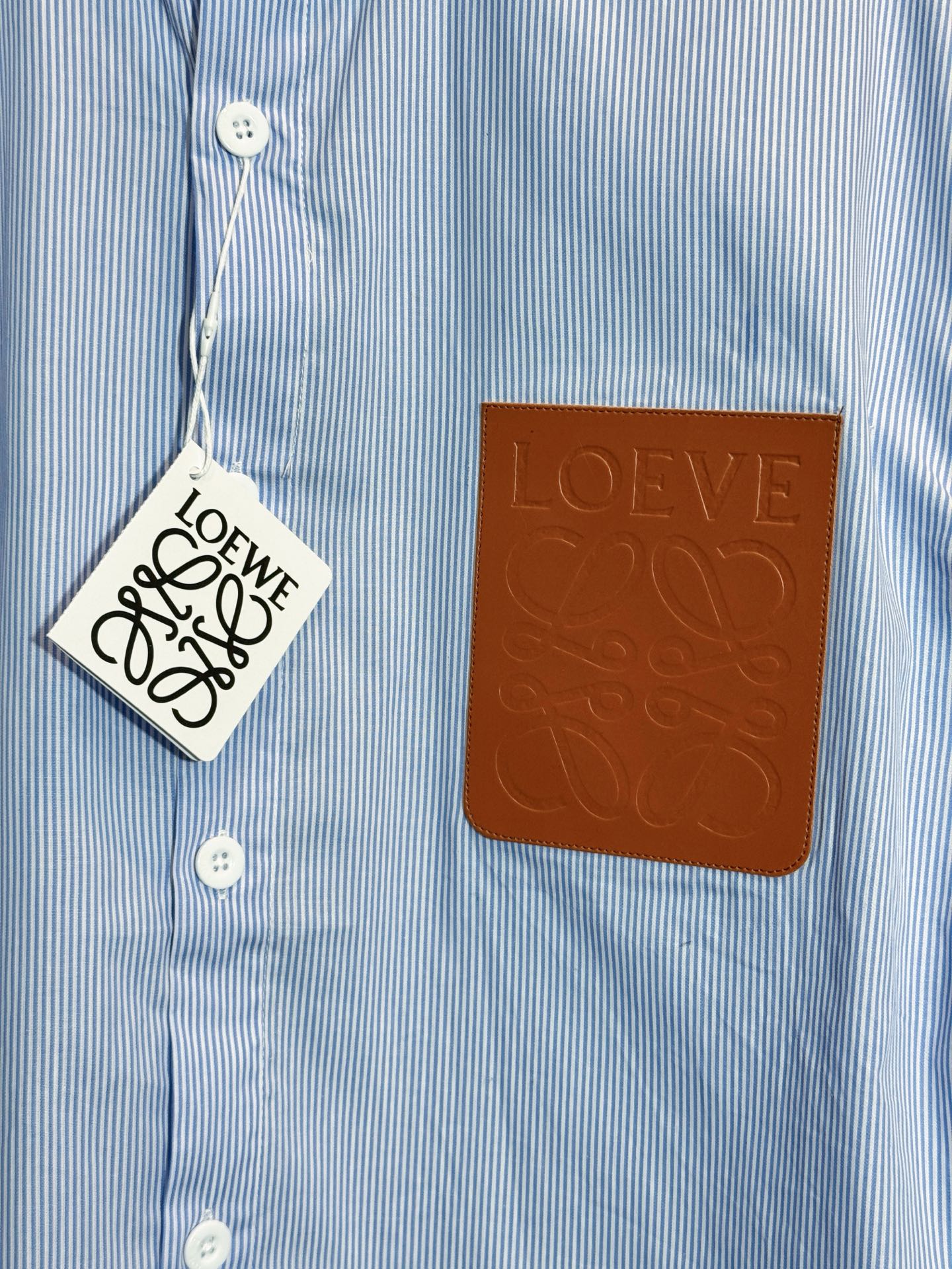 💰145
款号：HE328
LOEWE/罗意威秋季胸前皮标口袋条纹衬衫
面料采用经典条纹竹节棉面料，罗意威原版面料制作而成，胸前定制罗意威标识皮标口袋，三标齐全，秋季爆款，男女同款，OS版型，最大200斤无压力。

颜色：图片色
尺码：S-XL