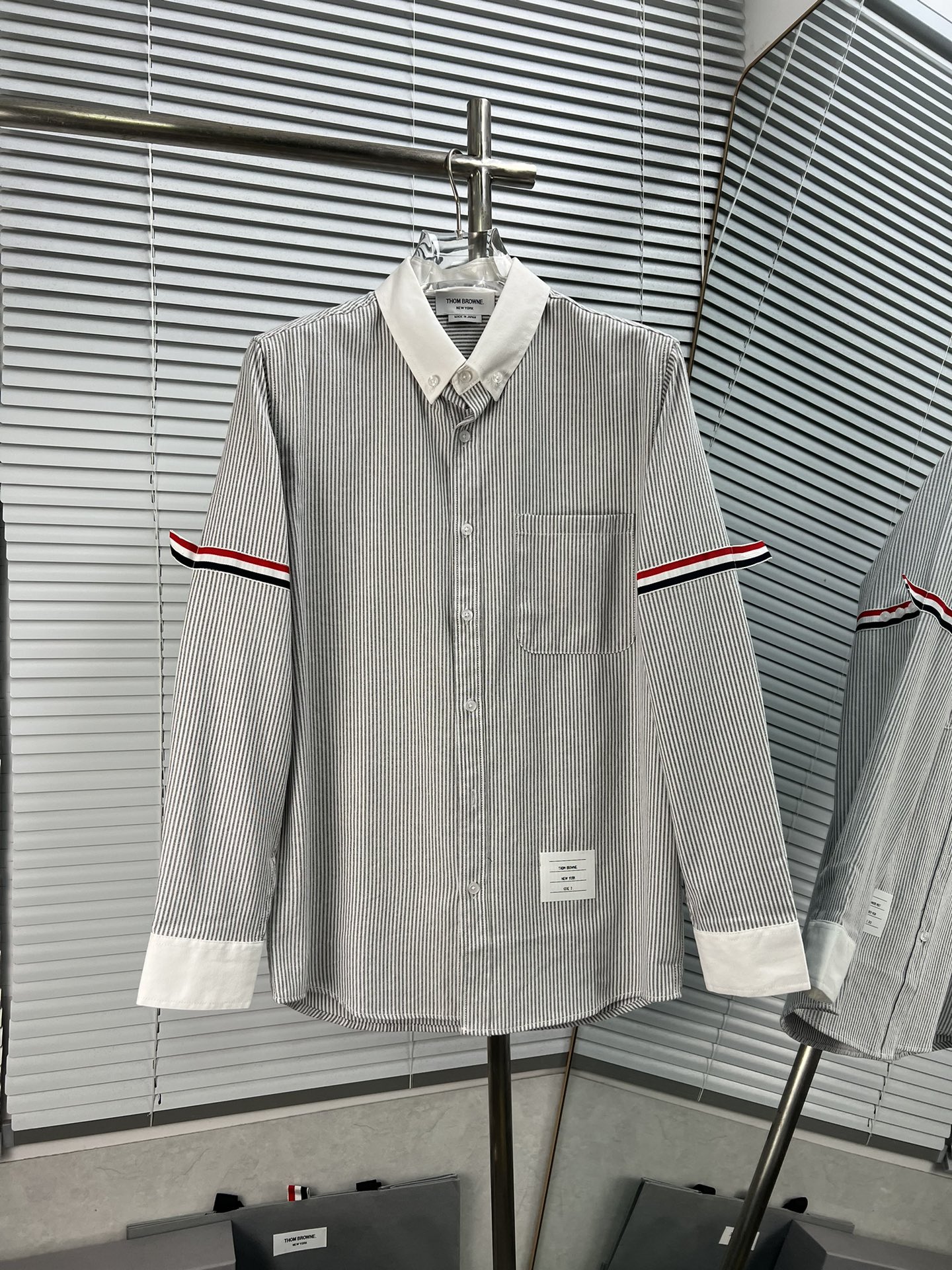 THOM BROWNE Camisa de manga larga con doble etiqueta en la manga, cuello blanco y colores combinados. Saber vestir una …