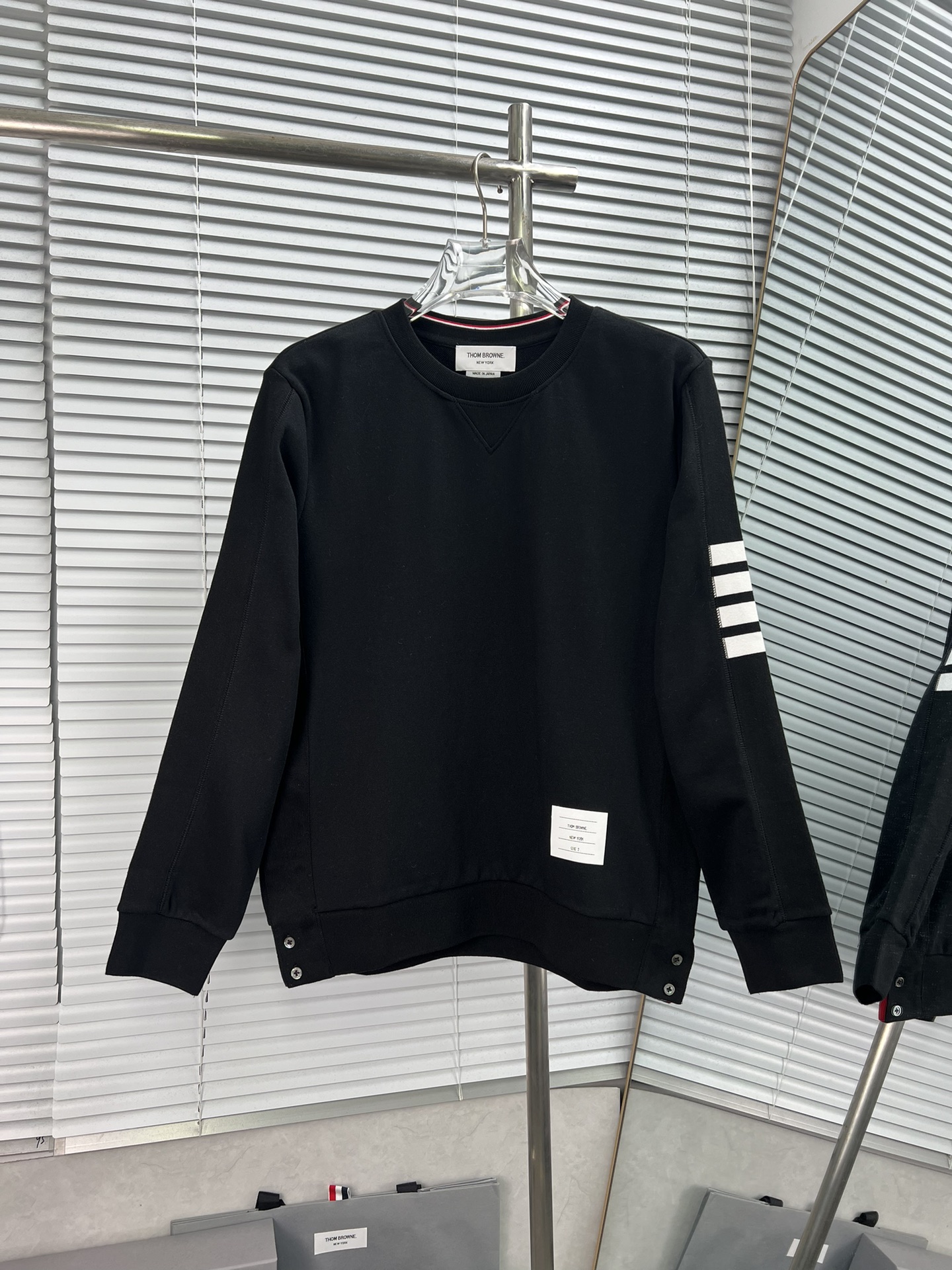 Sudadera de cuello redondo con cuatro barras laterales de THOM BROWNE. La versión clásica nueva tiene pequeño…