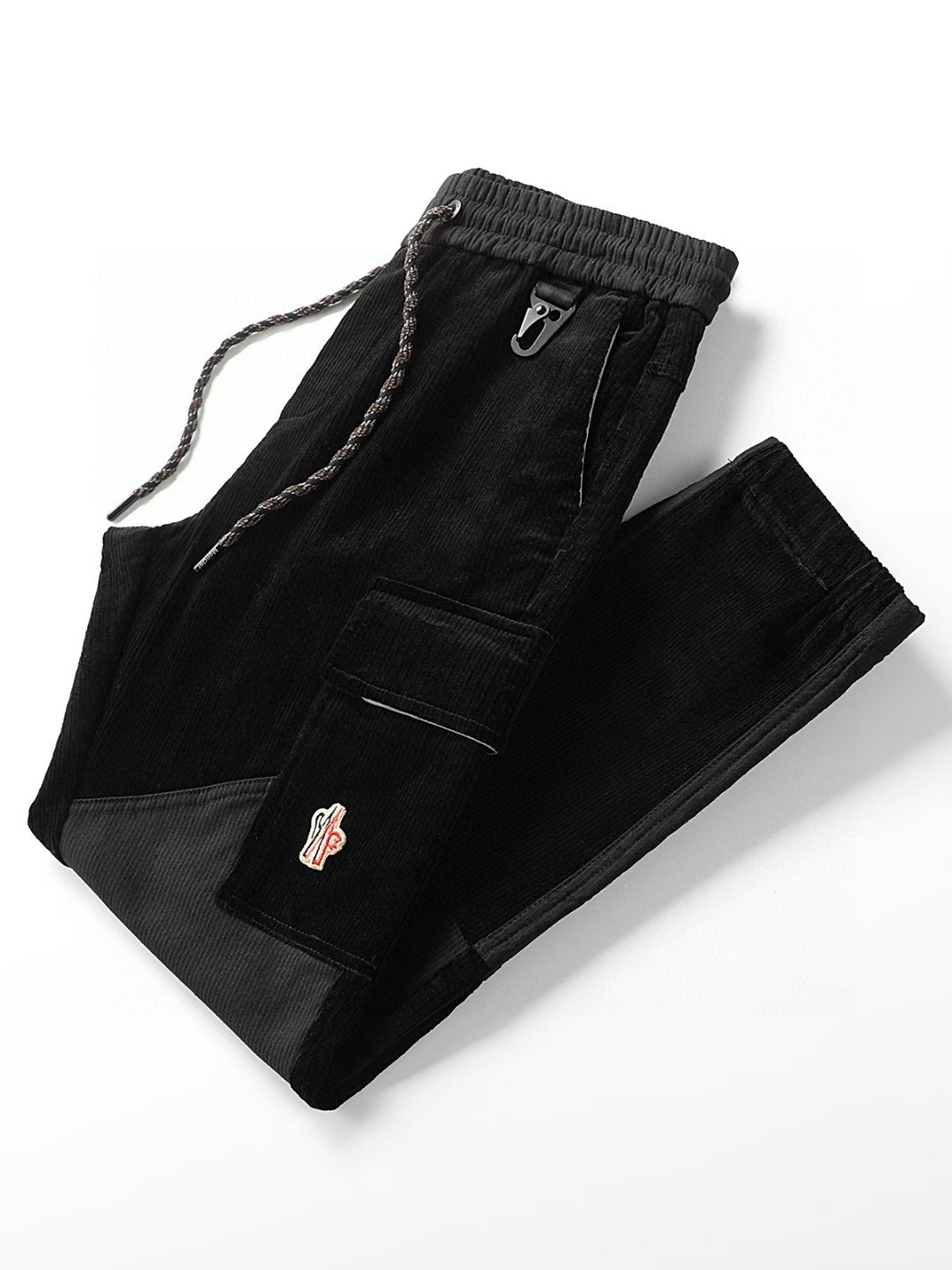 P180蒙*口 Mo**ler 25FW新款黑色灯芯绒抽绳休闲裤，贸易公司渠道稀出，领先官网发售！L家高端商务主线系列，应季必备的刚需精品，粗条纹灯芯绒洋溢别致复古魅力，丰富材质搭配修身版型，以利落现代的风格演绎休闲时尚！

这款裤装采用客供进口黑色灯芯绒面料制成，手感轻薄且柔软，表面绒感齐整，柔软细腻贴肤感巨舒适，灯芯绒坑条纹绒感纹理清晰，梳理齐整，精致感足！展现精致细节！基础直筒的休闲裤装版型剪裁，不仅百搭还可以起到修饰腿型的功效，各位男士们一定要把握住机会 M-3XL