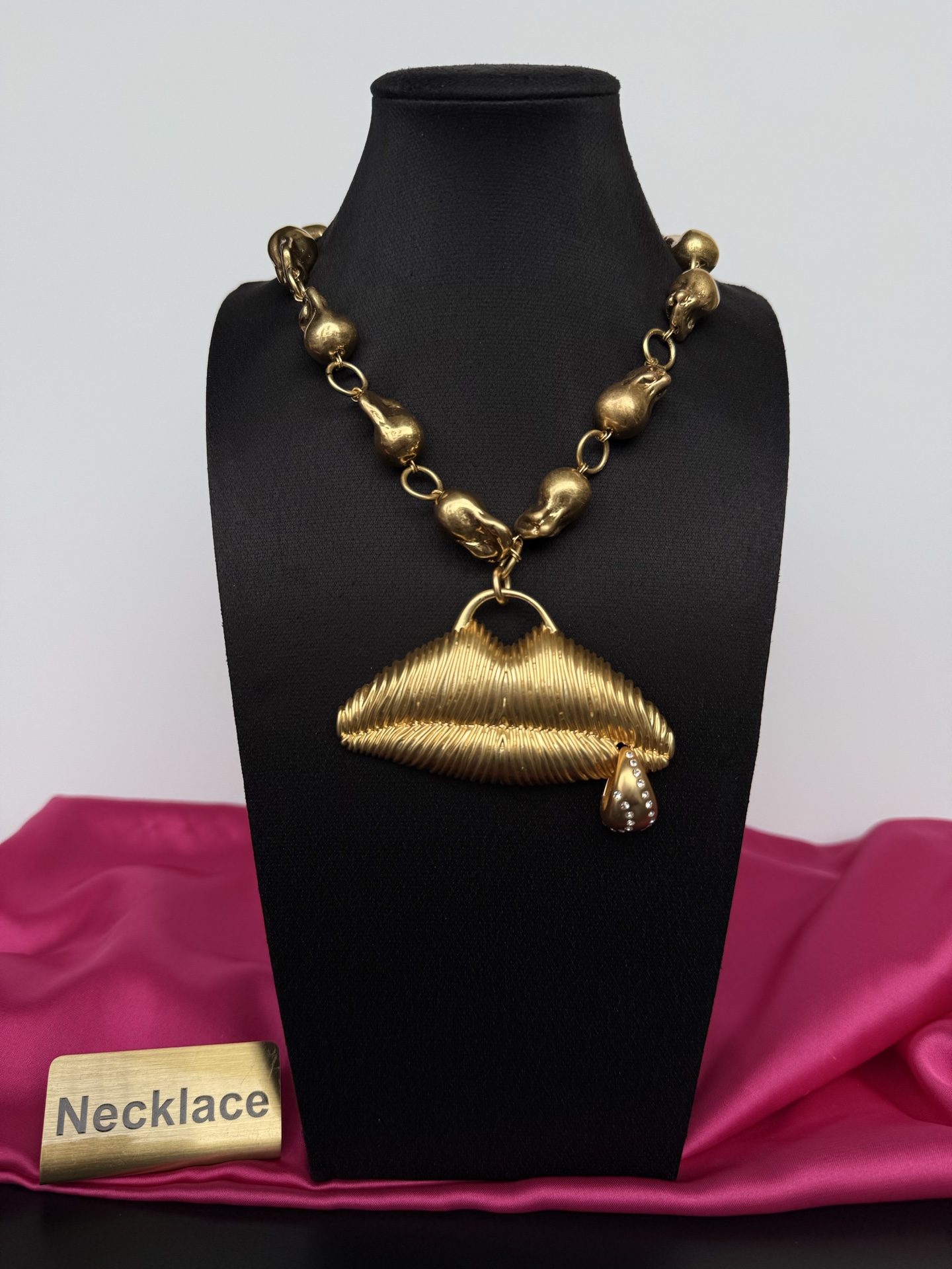 Золотистое колье с подвеской в виде губ Schiaparelli