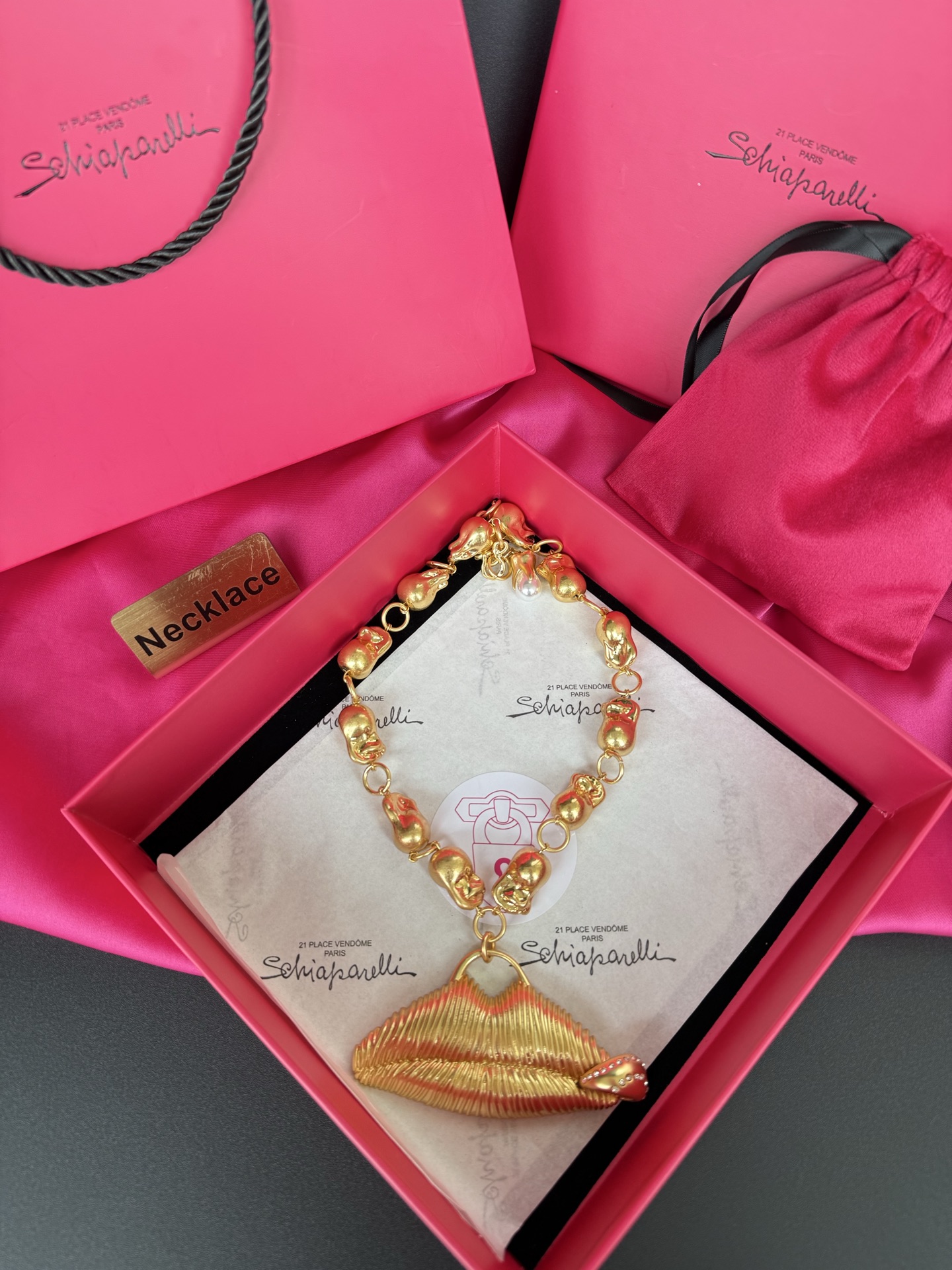 Золотистое колье с подвеской в виде губ Schiaparelli